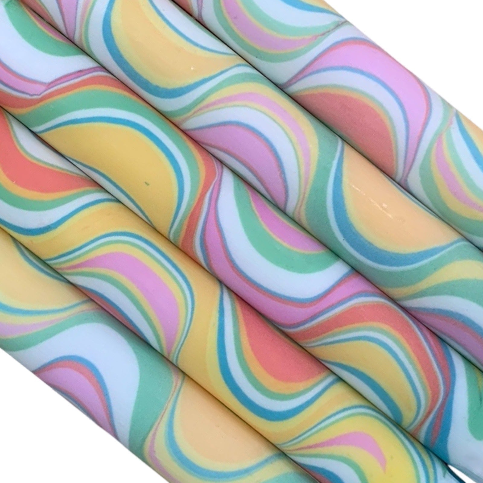 A row of 5 handmade dinner candles marbled in shades of yellow, pink, green and white.