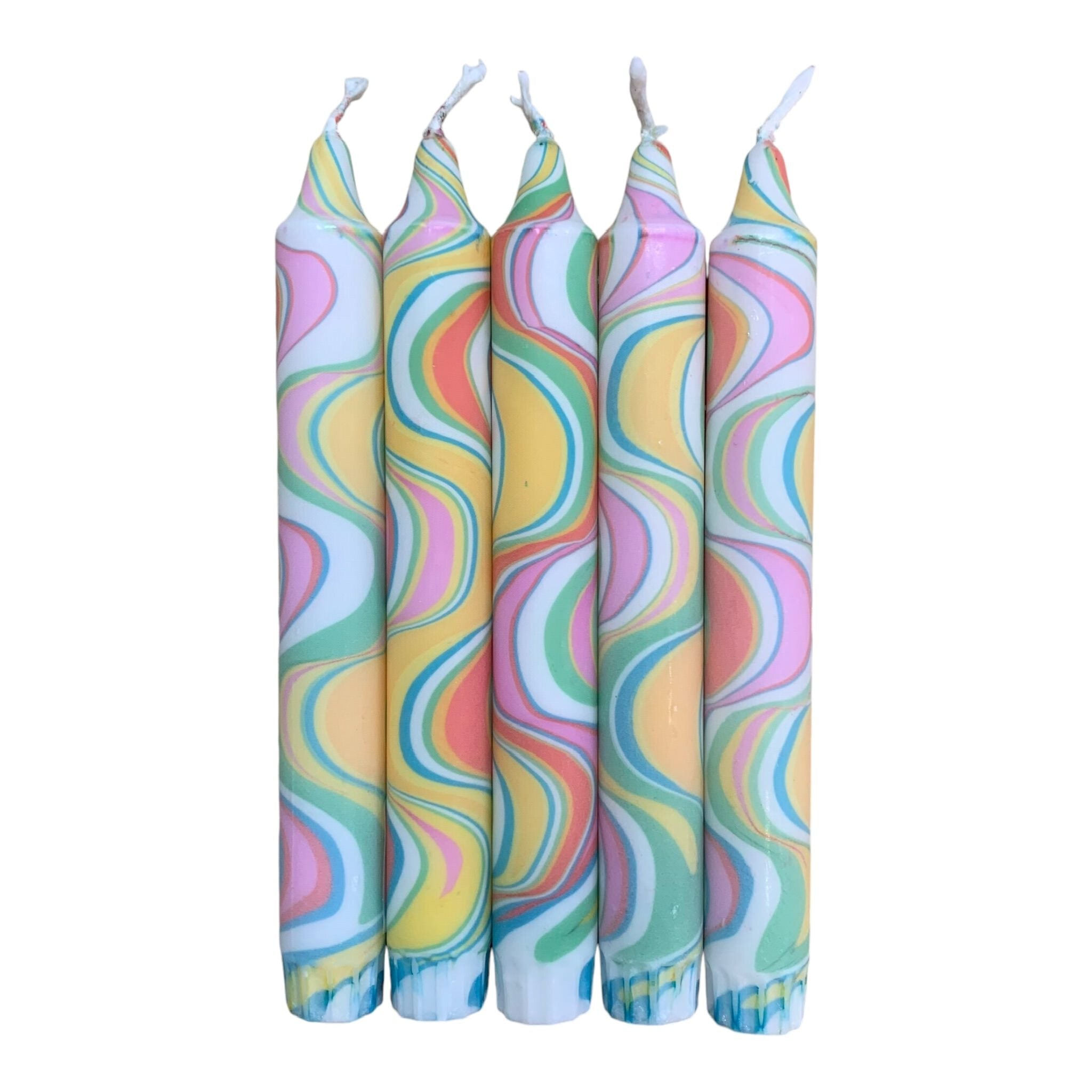 A row of 5 handmade dinner candles marbled in shades of yellow, pink, green and white.