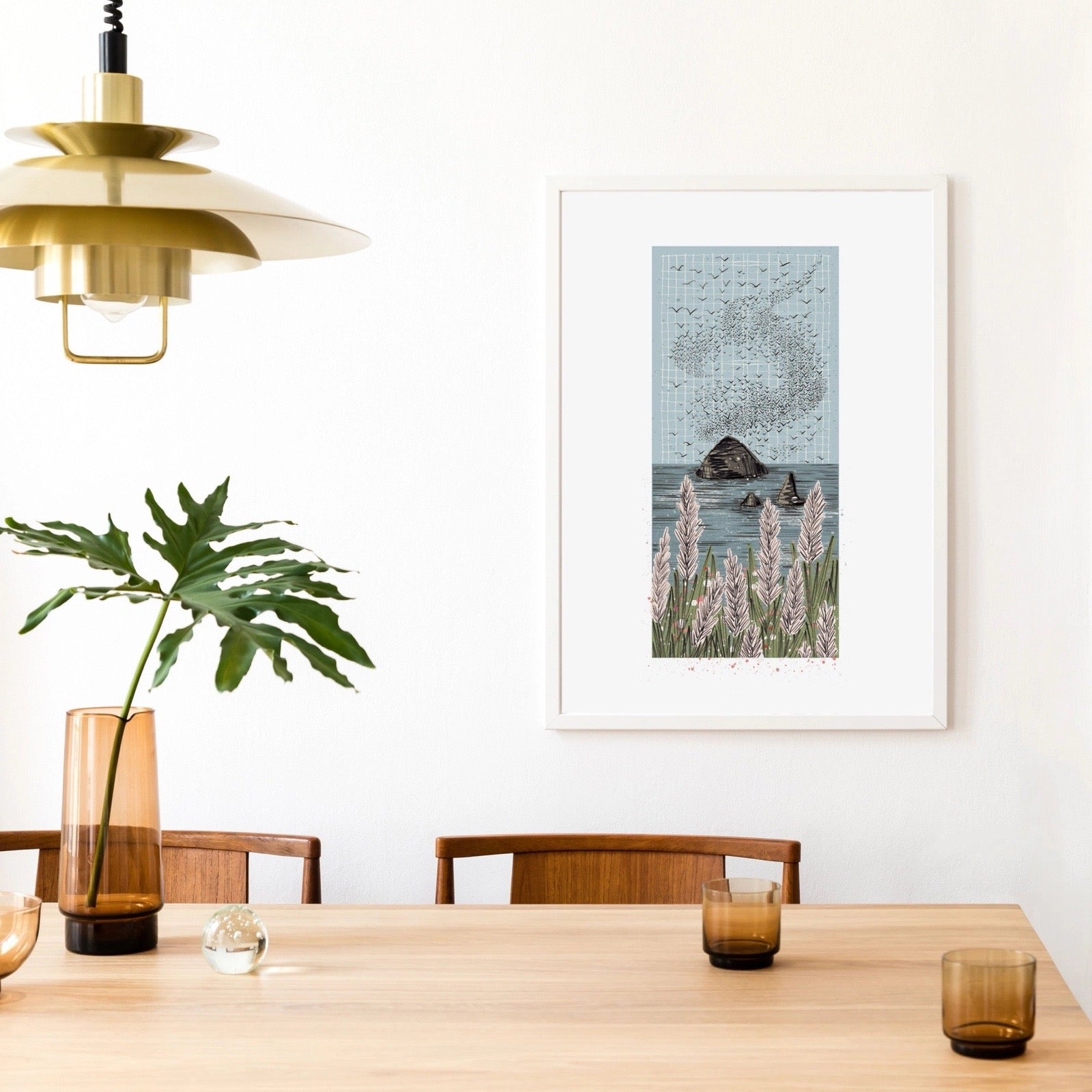 Dining room with wooden table, chairs, and a framed picture of birds over water.