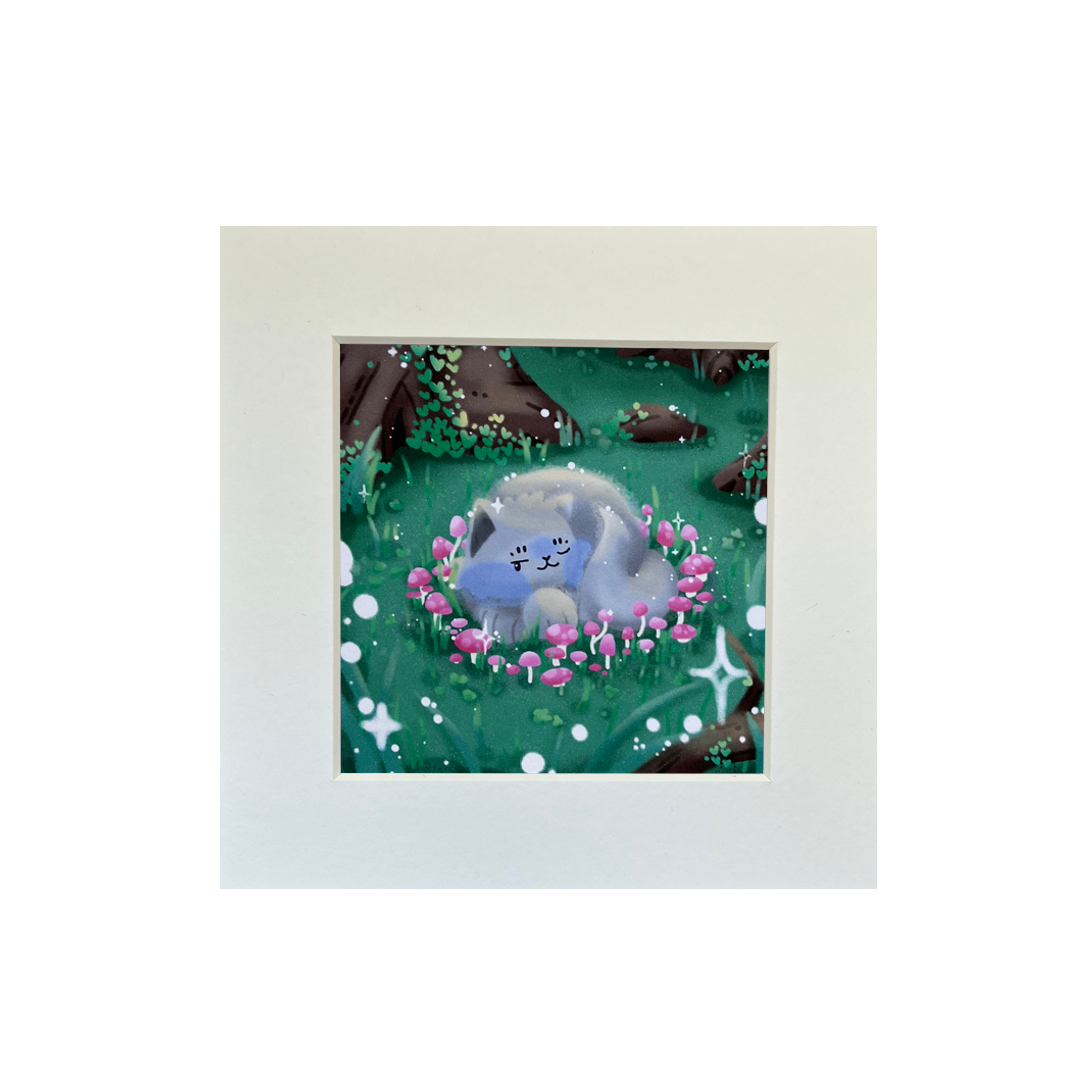 Illustrated print of a grey cat curled up inside a pink, mushroom, fairy circle in the middle of a forest. Includes white sparkle details.