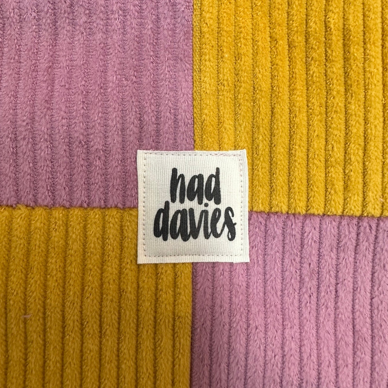 Close-up of a ribbed fabric with a 'had davies' label.