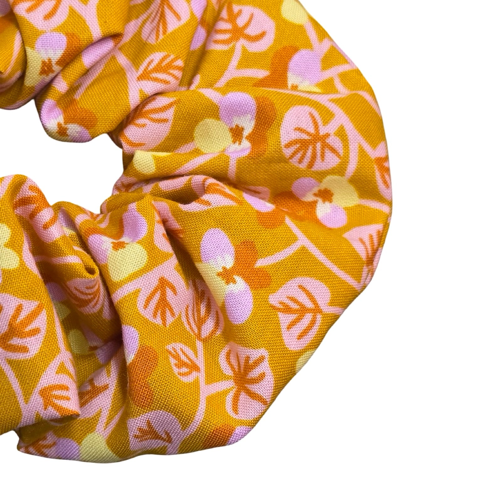 This mustard handmade hair scrunchie is made from 100% cotton fabric with small lilac and yellow violets and pale pink leaves.