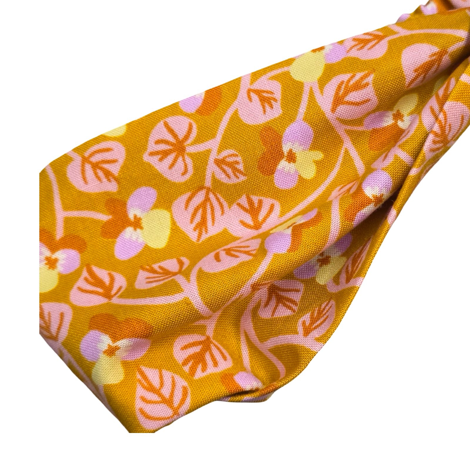 This handmade mustard floral knotted headband is made from 100% cotton fabric with small lilac and yellow violets and pale pink leaves.