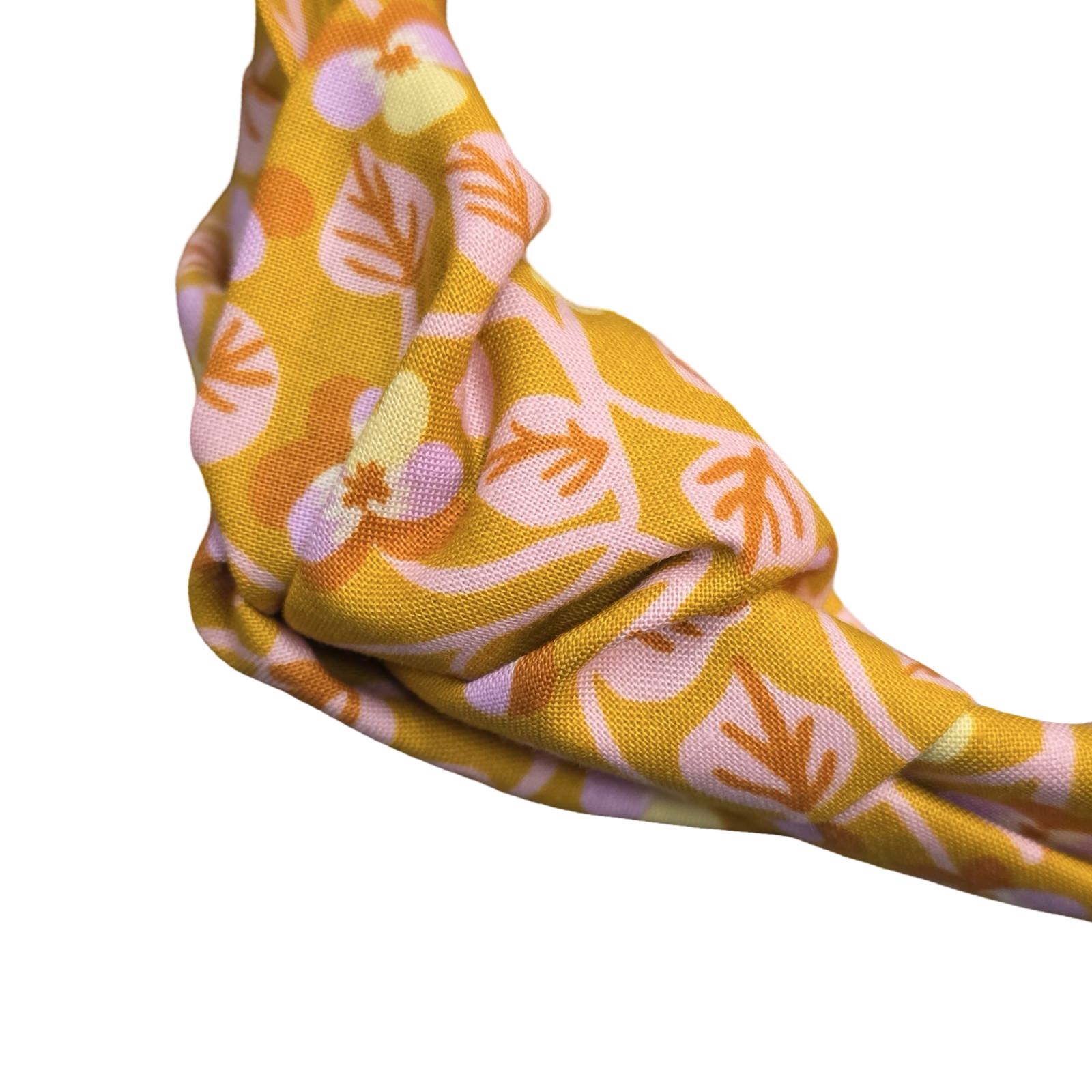 This mustard handmade floral top-knot Alice band is made from 100% cotton fabric with small lilac and yellow violets and pale pink leaves. 