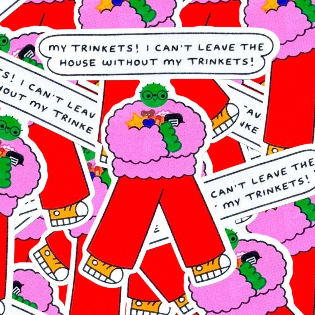Stickers in a pile featuring a cartoon character with a pink fuzzy jumper, red pants, yellow shoes, and a green head, with a speech bubble above reading 'MY TRINKETS! I CAN'T LEAVE THE HOUSE WITHOUT MY TRINKETS!'.