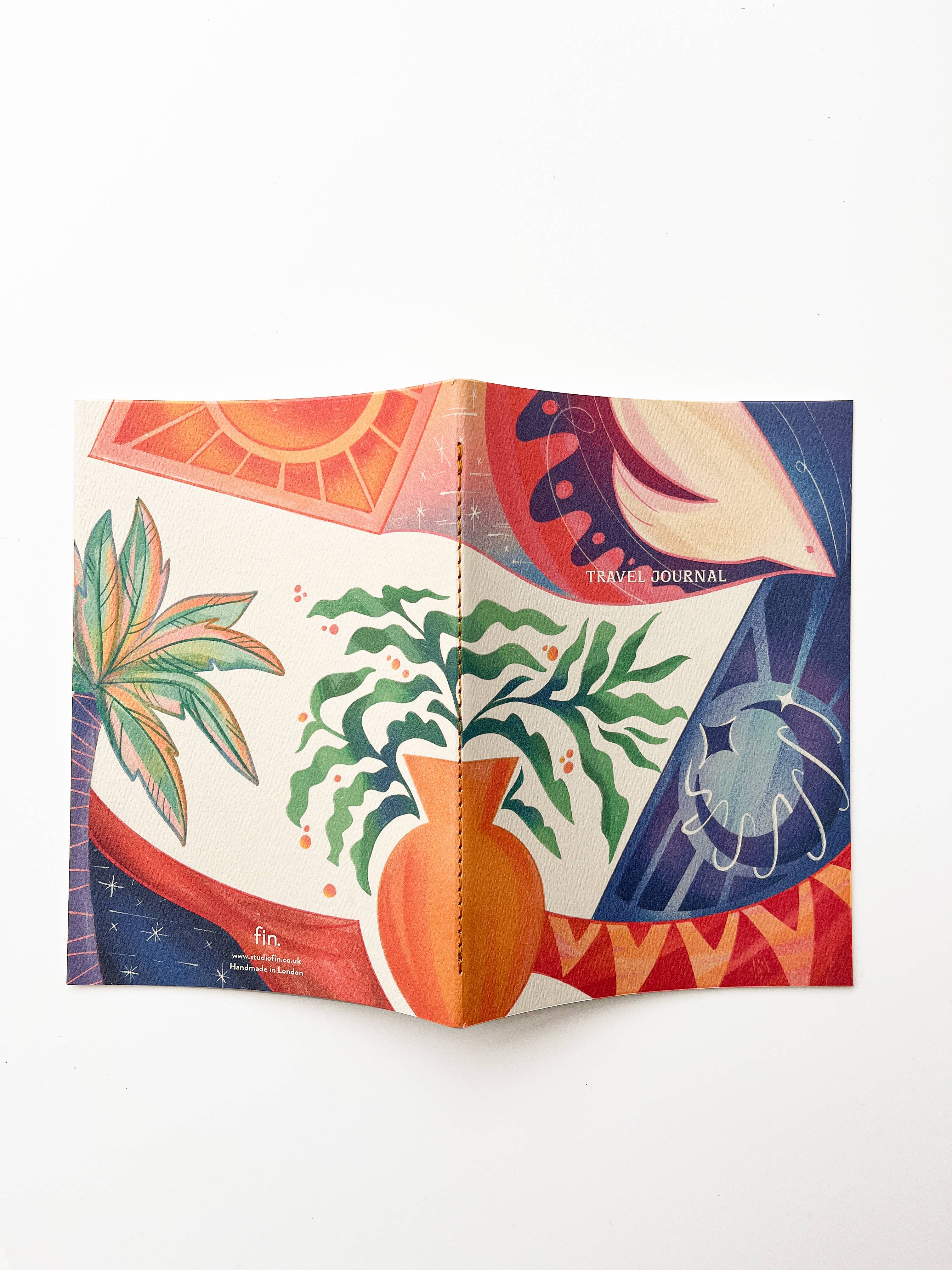 Colorful travel journal with artistic plant designs on a white background.