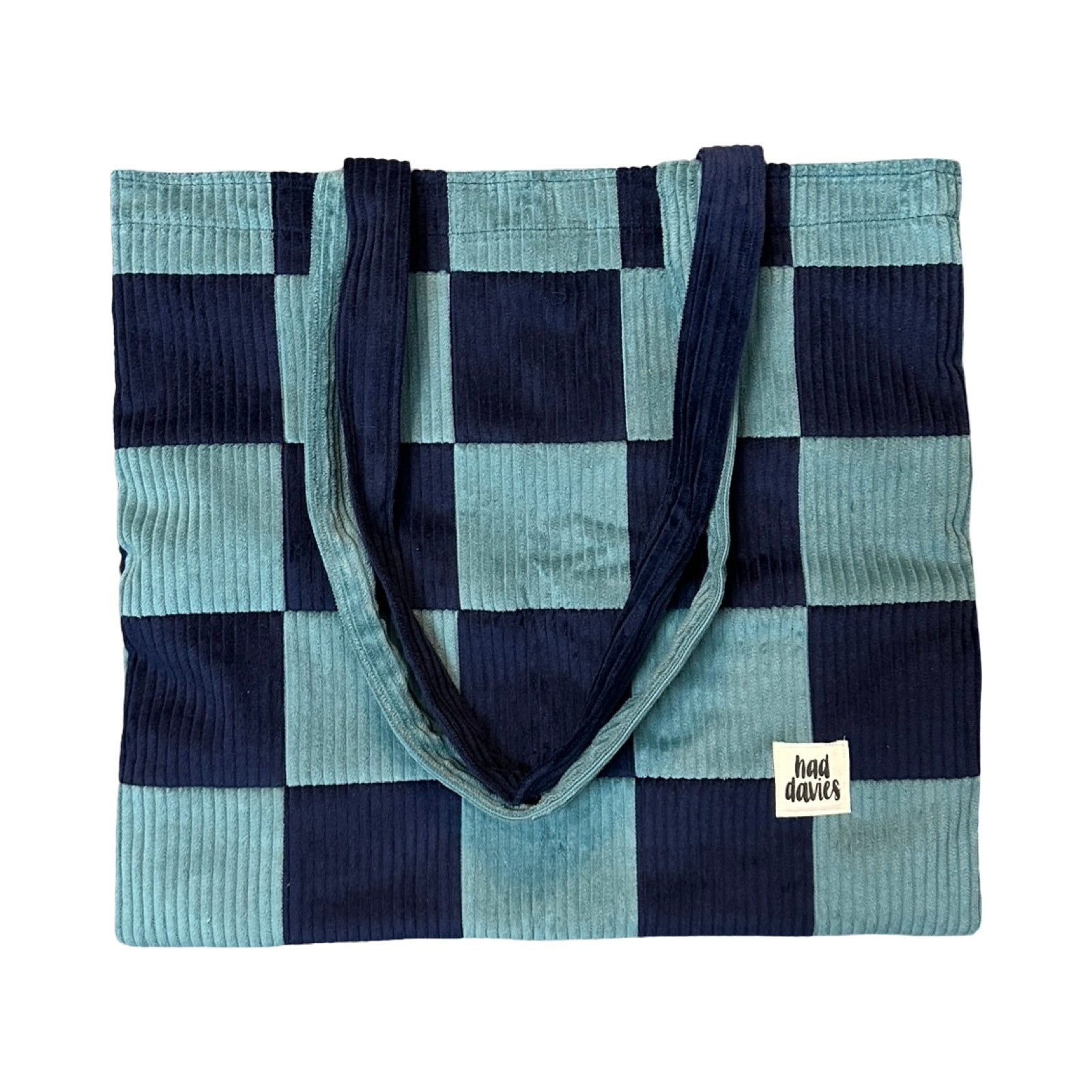 Checkered tote bag with blue and navy pattern on a white background.