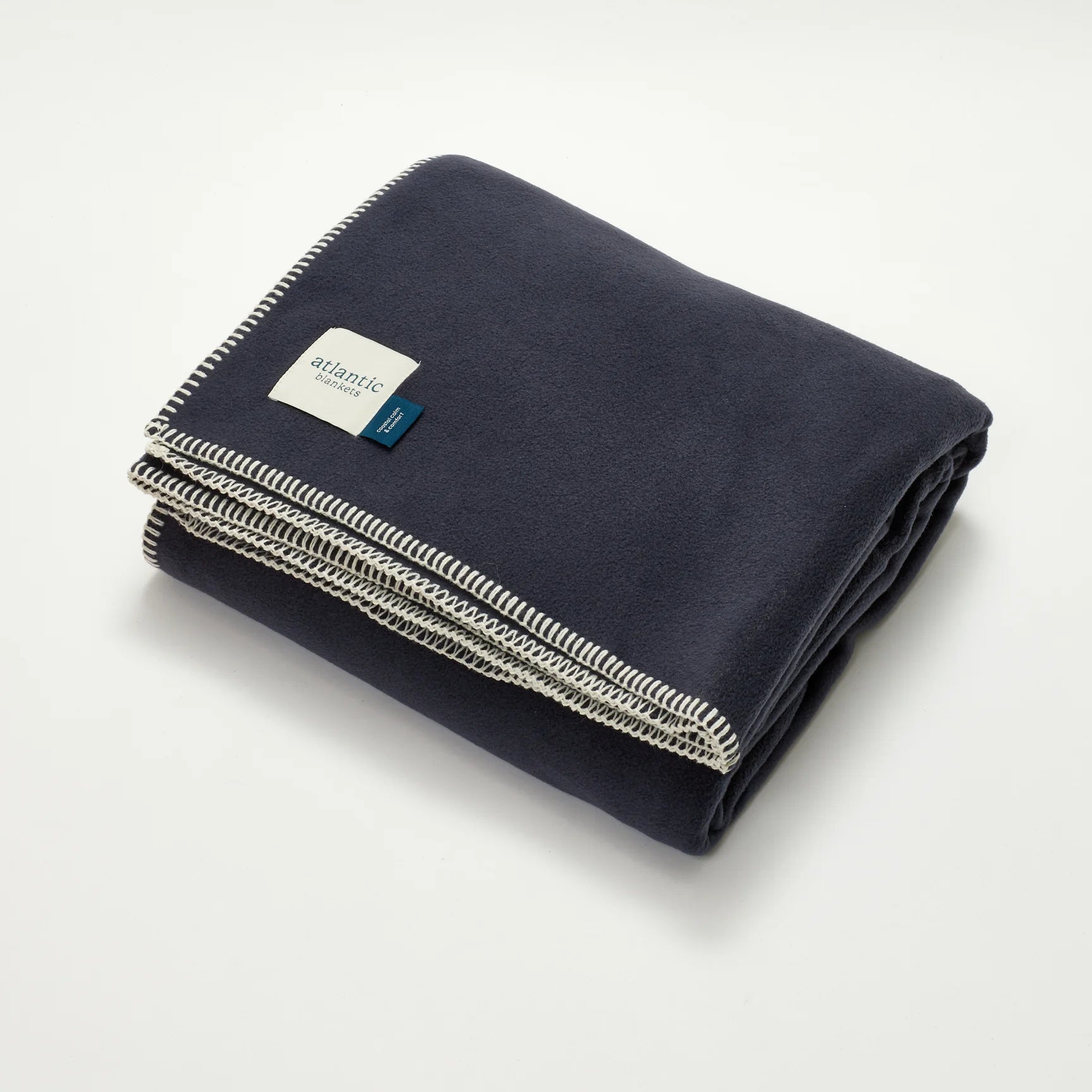 Folded navy blanket with an Atlantic Blankets brand label on a light grey background.