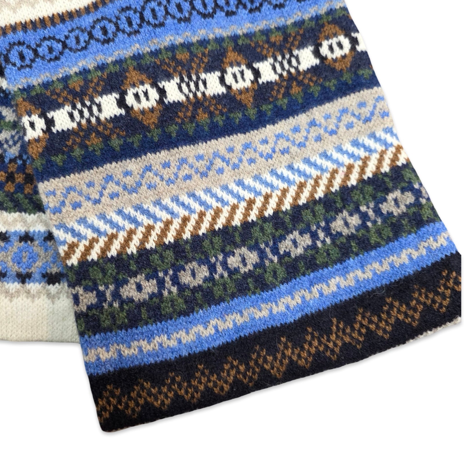 Knitted fabric with a pattern of blue, white, and brown stripes on a white background.