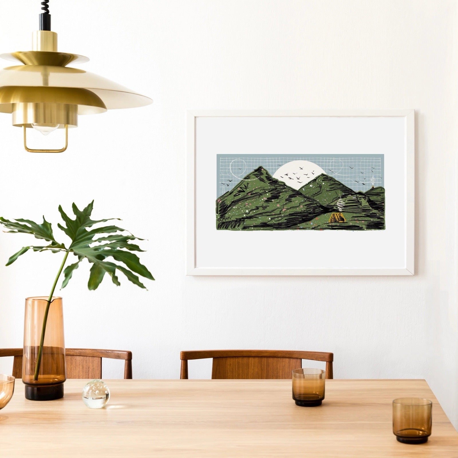 Dining room with a table, chairs, and a framed mountain print on the wall.