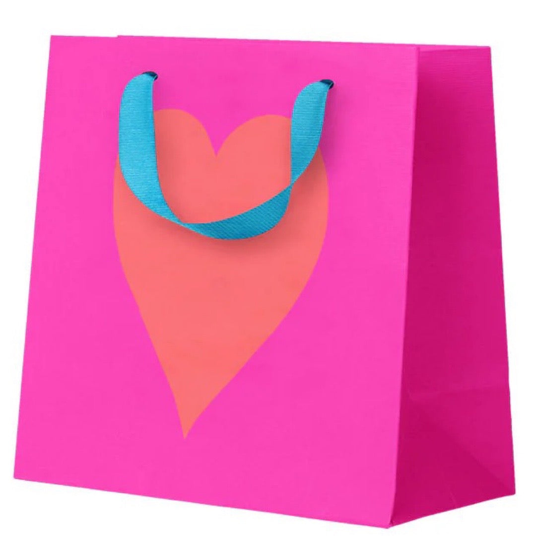 Pink gift bag with a heart design and blue handles on a white background.