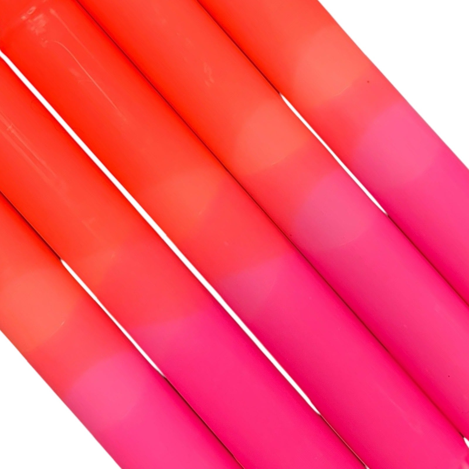 A row of 5 handmade dinner candles with a bright pink base and orange top.