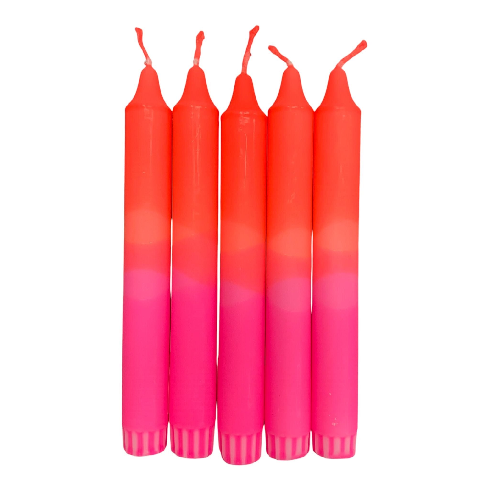 A row of 5 handmade dinner candles with a bright pink base and orange top.
