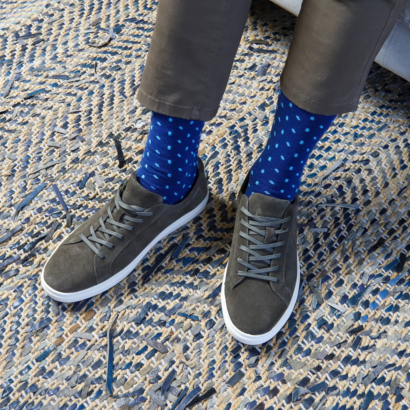 Person wearing blue shows on a blue and beige background.