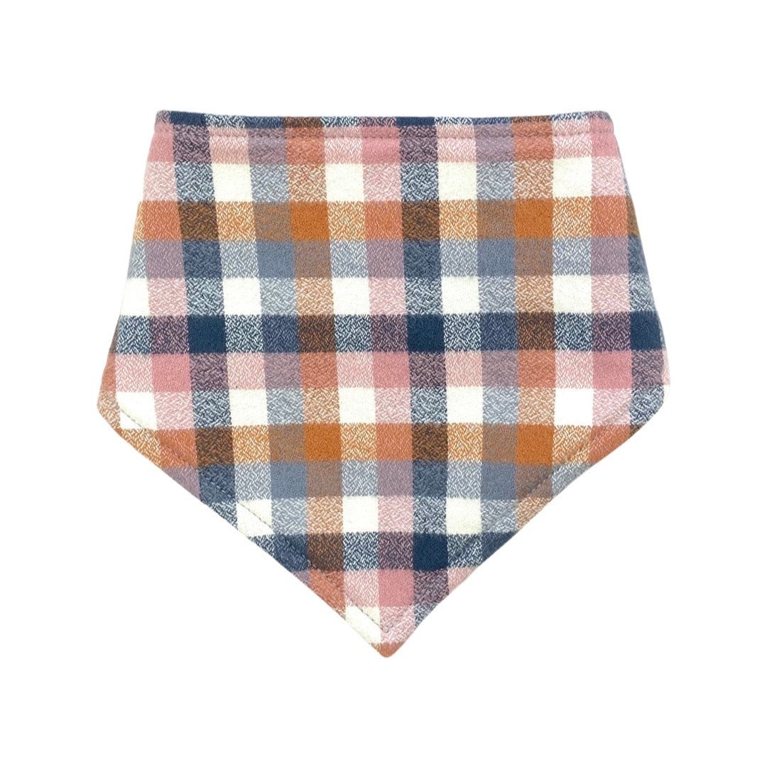 A bandana bib in a nutmeg check fabric, featuring a plaid pattern with blue and orange colors.