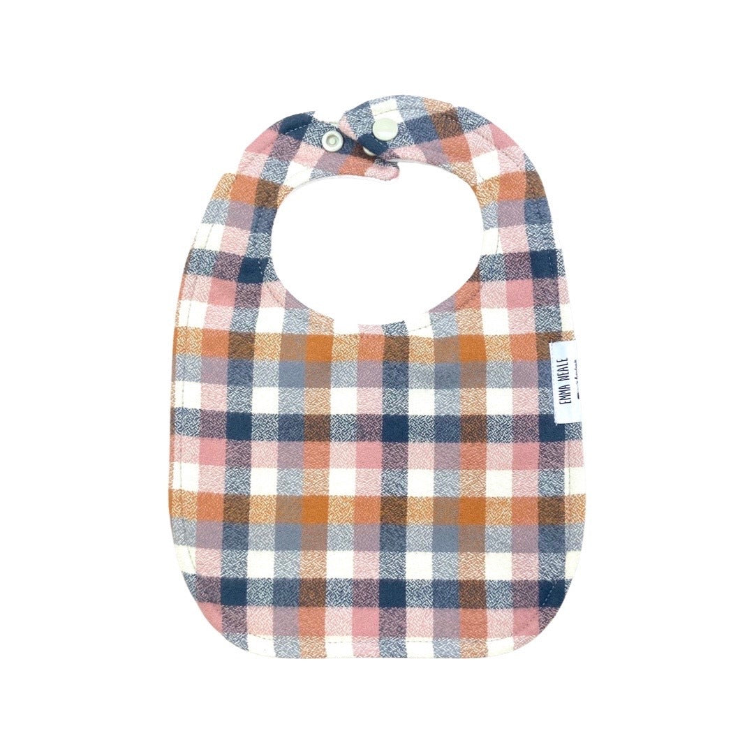 Traditional style bib in 'nutmeg check' fabric with adjustable neck fasteners.