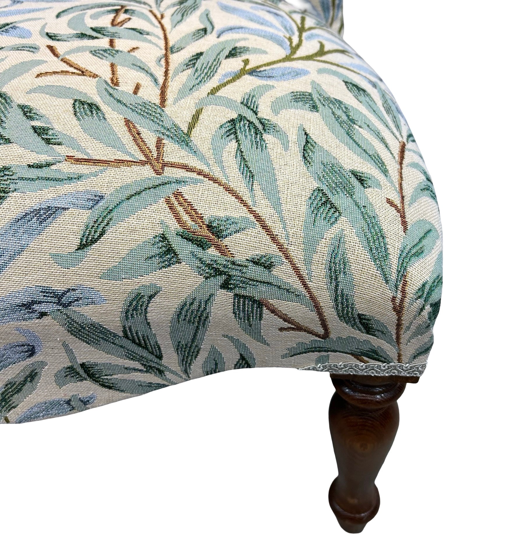 Chair with leaf patterned fabric on a white background.
