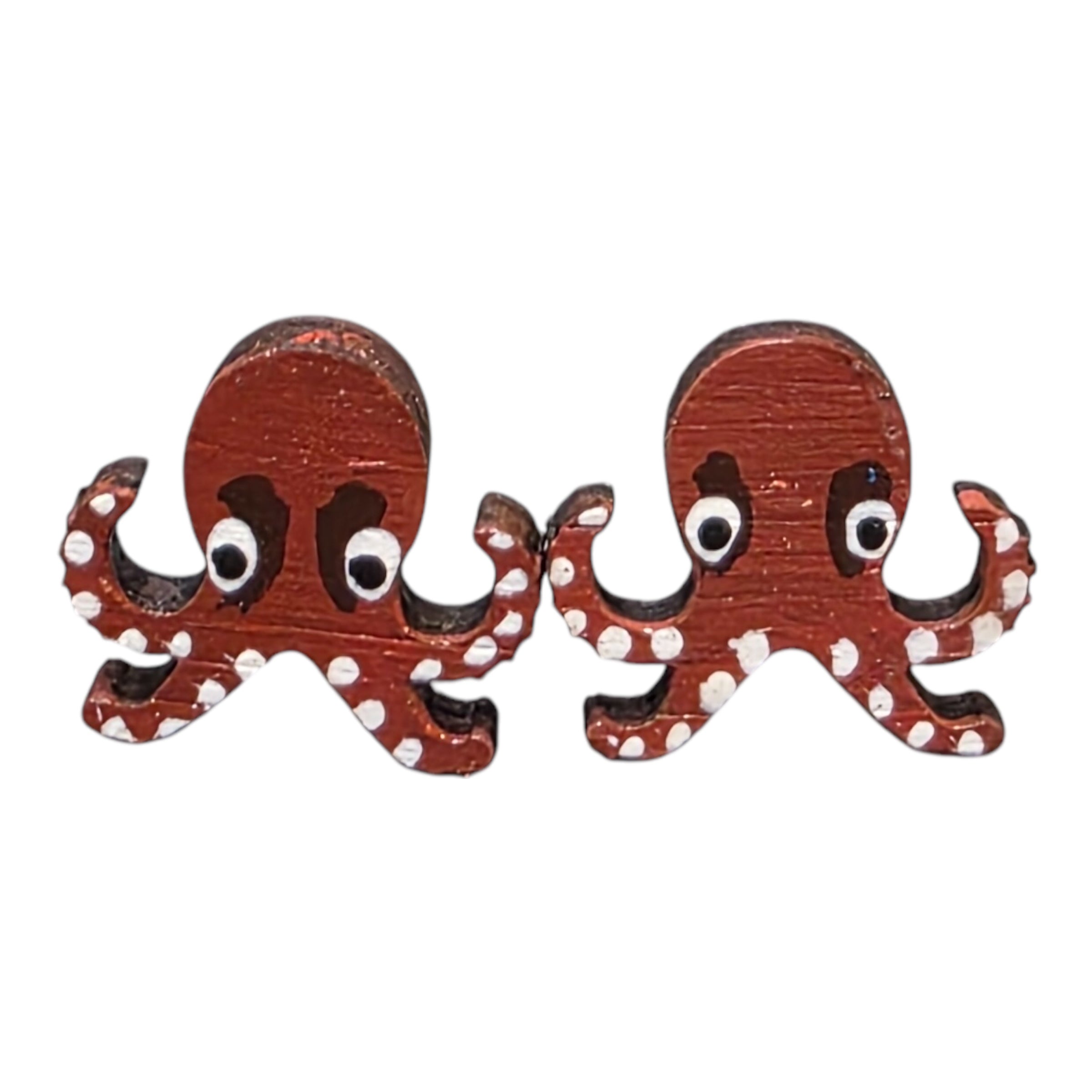 A pair of pink octopus-shaped wooden earrings.