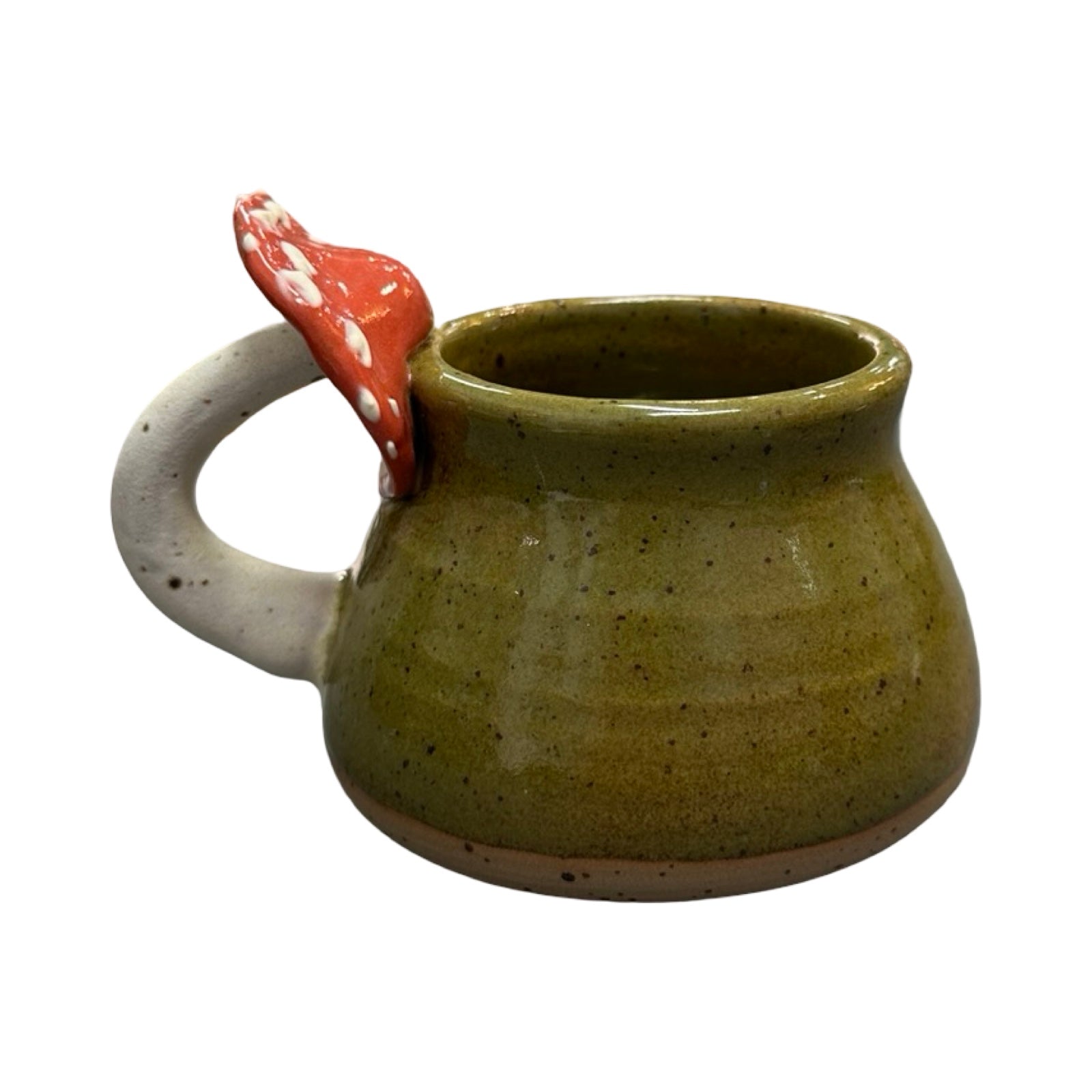 Green ceramic mug with a red and white mushroom handle on a white background.