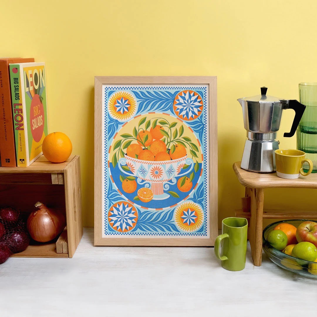 Decorative print with orange design on a shelf with kitchen items.