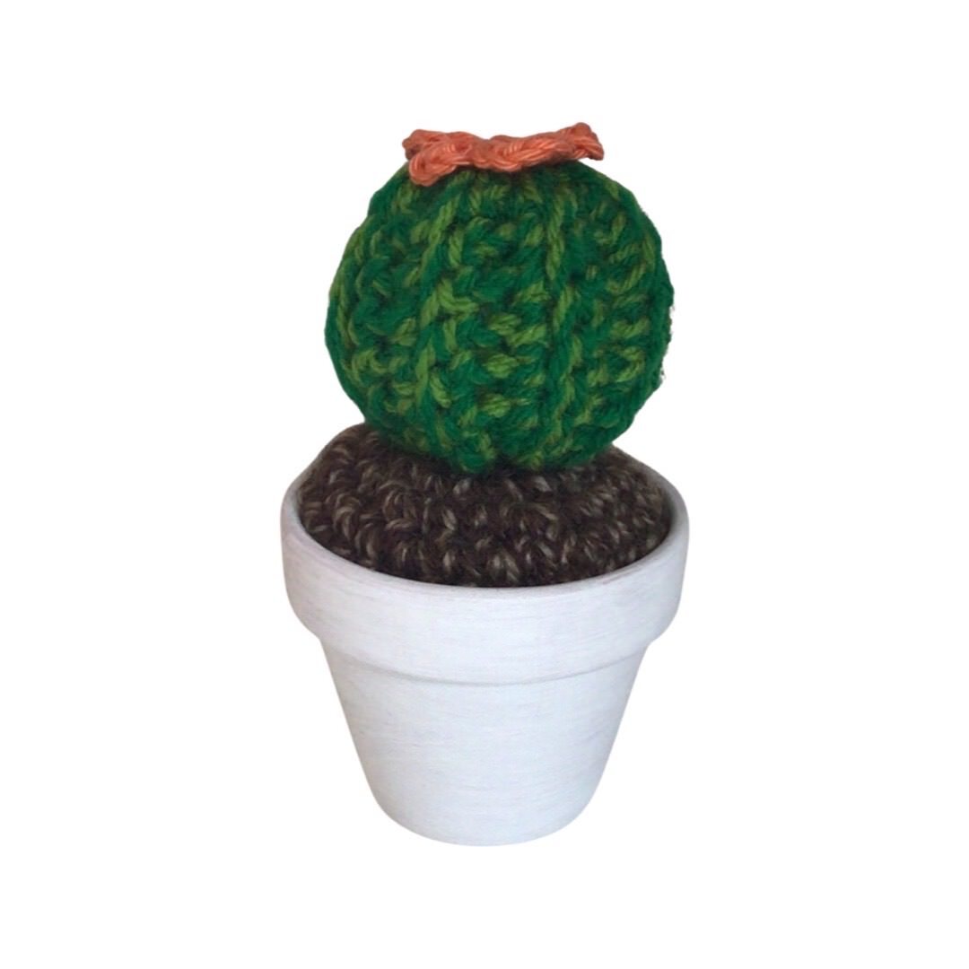 Handmade round crochet cactus with an orange flower. 