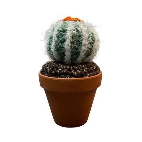 Handmade round crochet cactus with an orange flower in a terracotta pot. 
