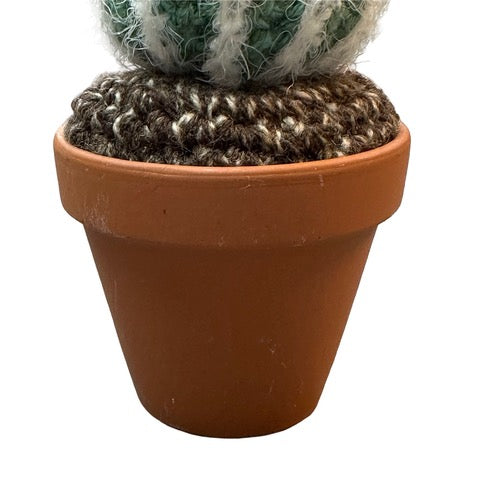 Handmade round crochet cactus with an orange flower in a terracotta pot. 