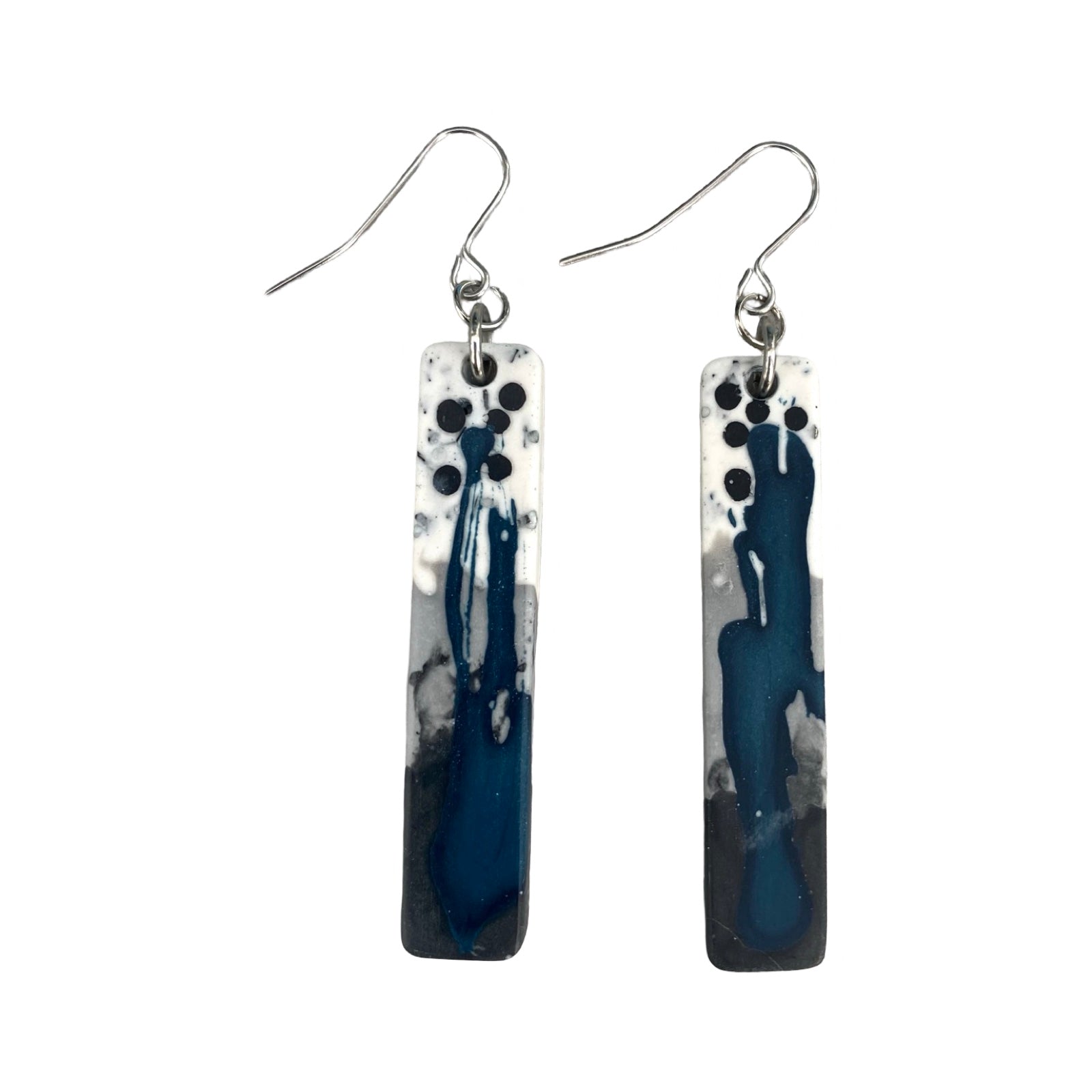 A pair of long rectangular earrings in a blue, grey, black and white paint design on silver ear hooks.