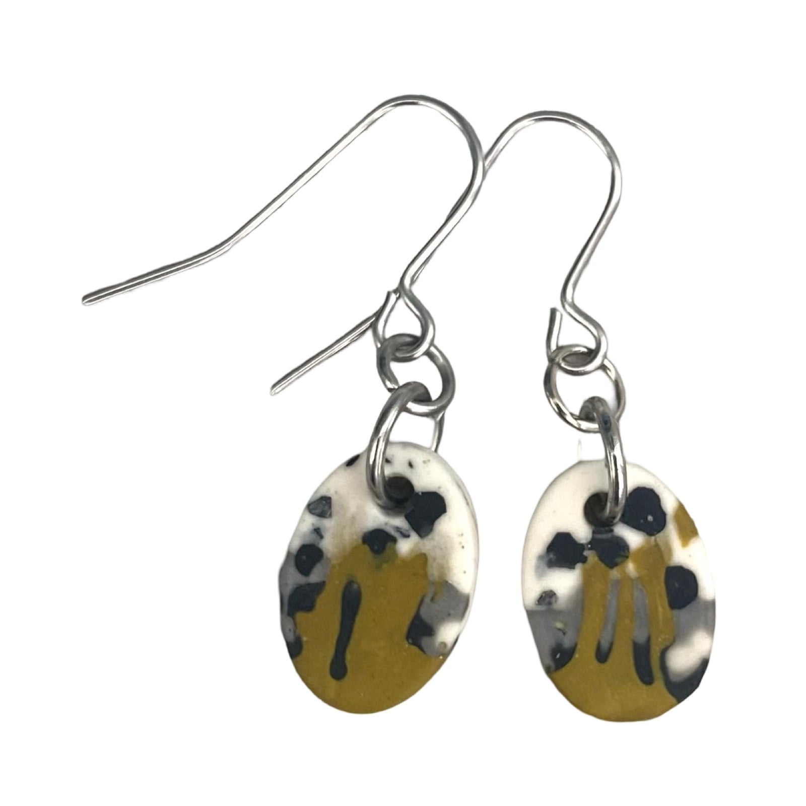 Oval drop earrings in a mustard, black, grey and white paint design on silver ear hooks.