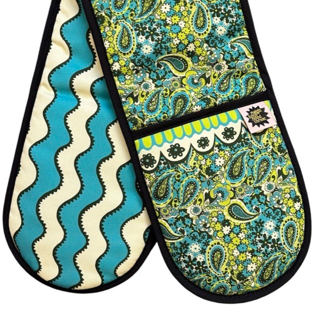 Green and blue paisley pattern design oven gloves with turquoise and cream wiggly stripes on the reverse.