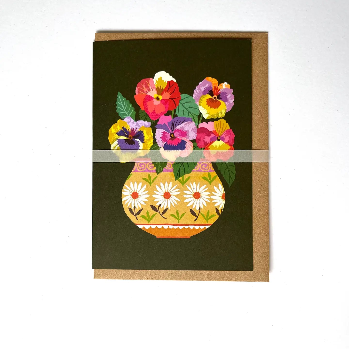 Greeting card with colourful floral design on a dark green background, with a brown envelope.