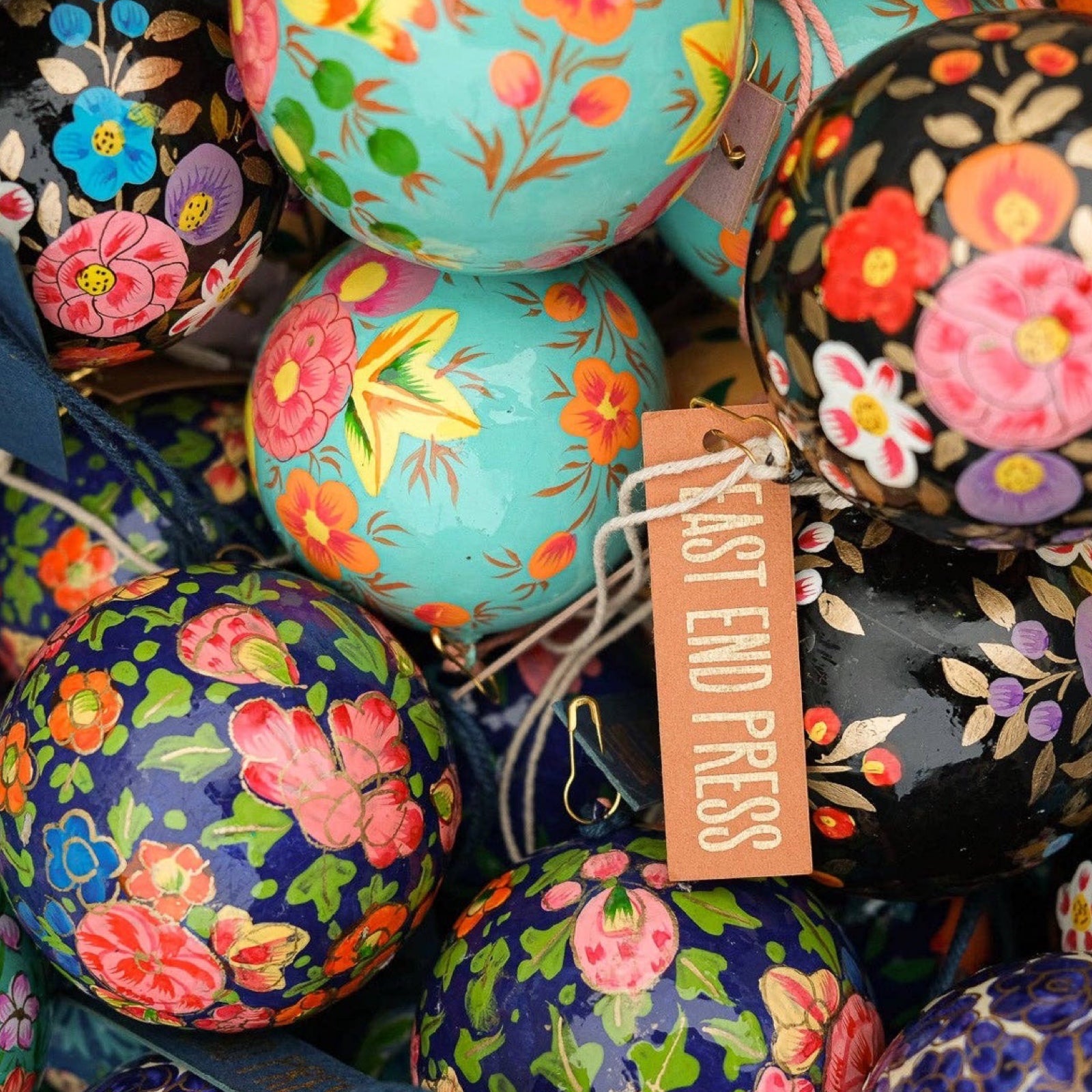 A collection of round, colourful papier mache baubles.