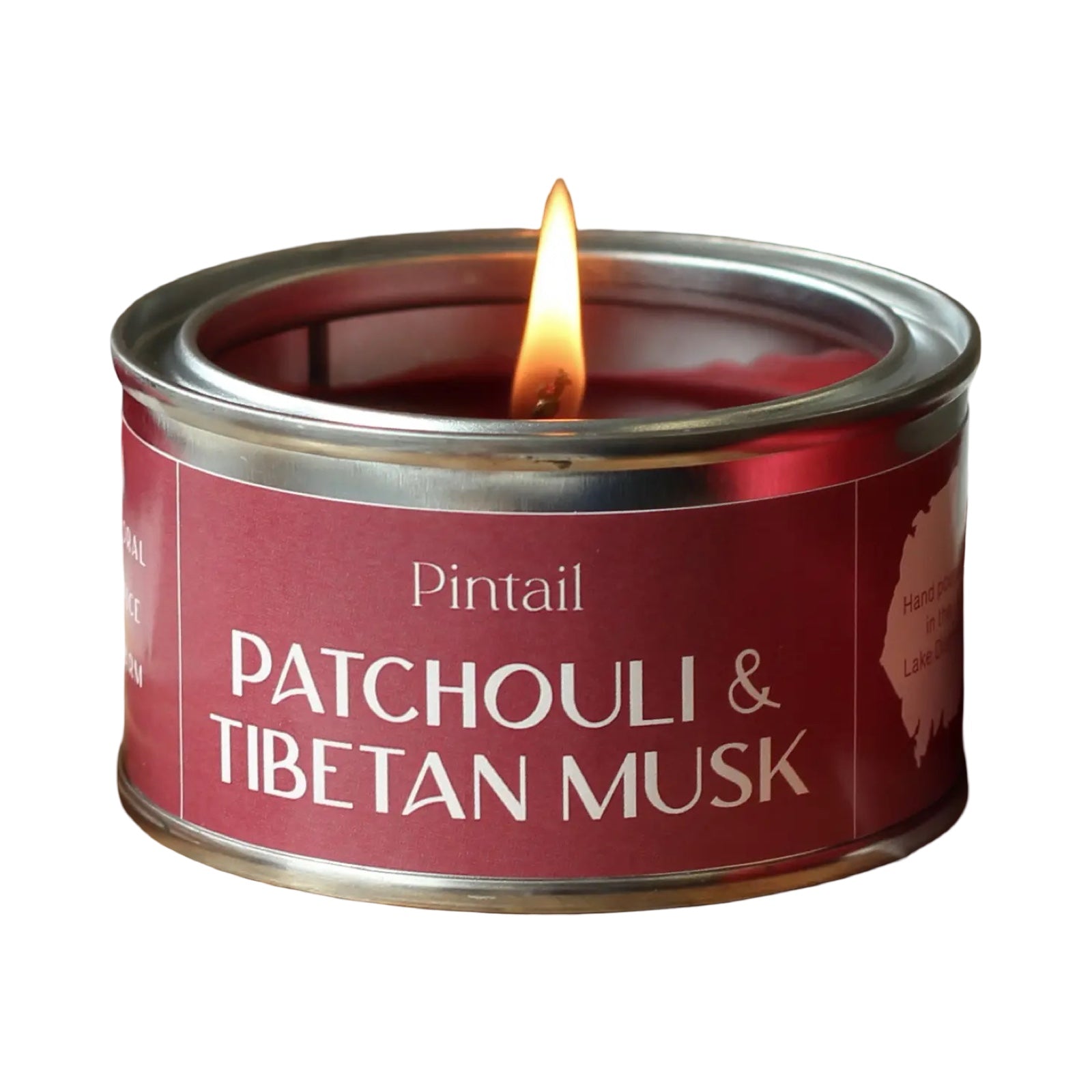 Candle in a red tin labeled 'Pintail Patchouli & Tibetan Musk' on a white background.