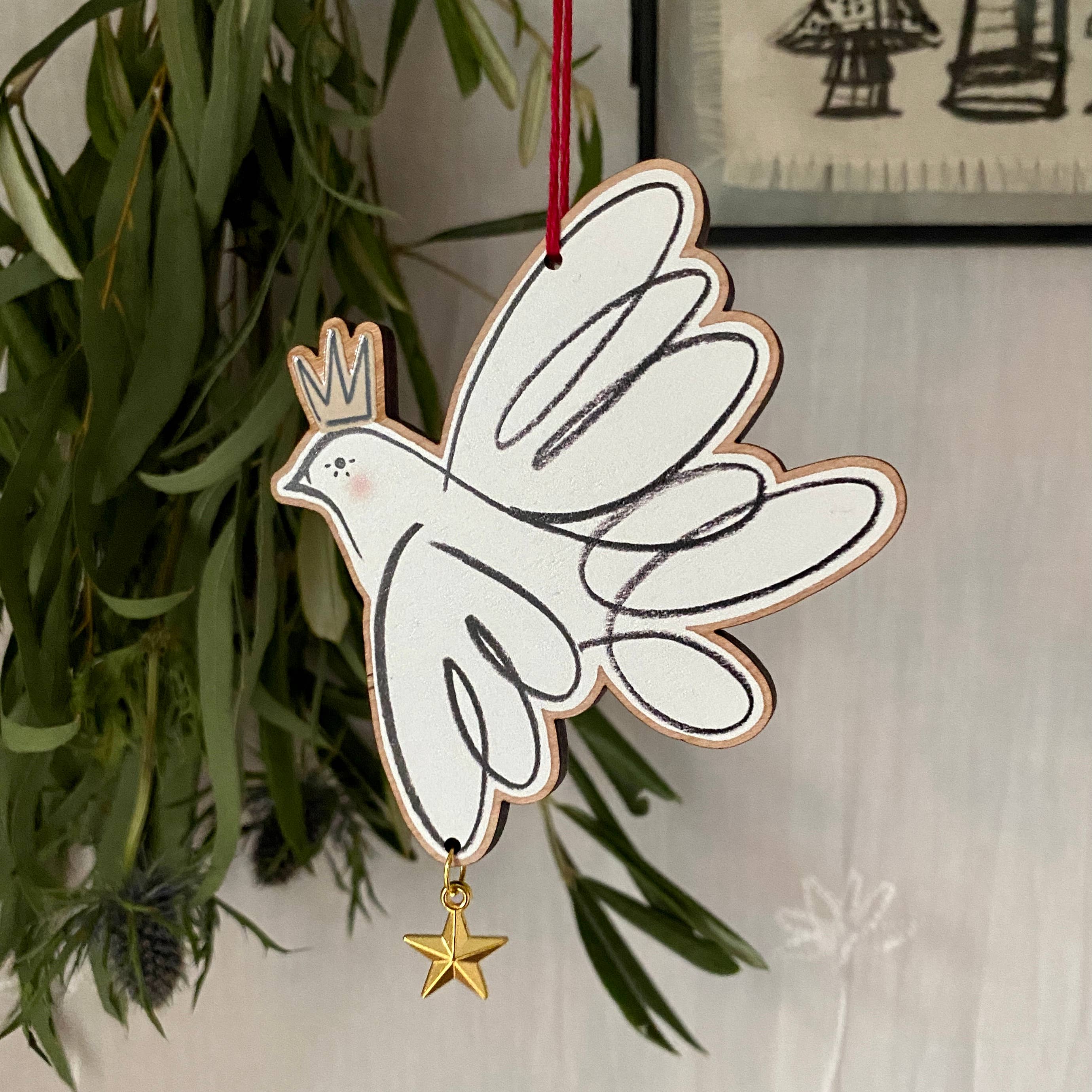 Decorative dove ornament with a star hanging on a plant.
