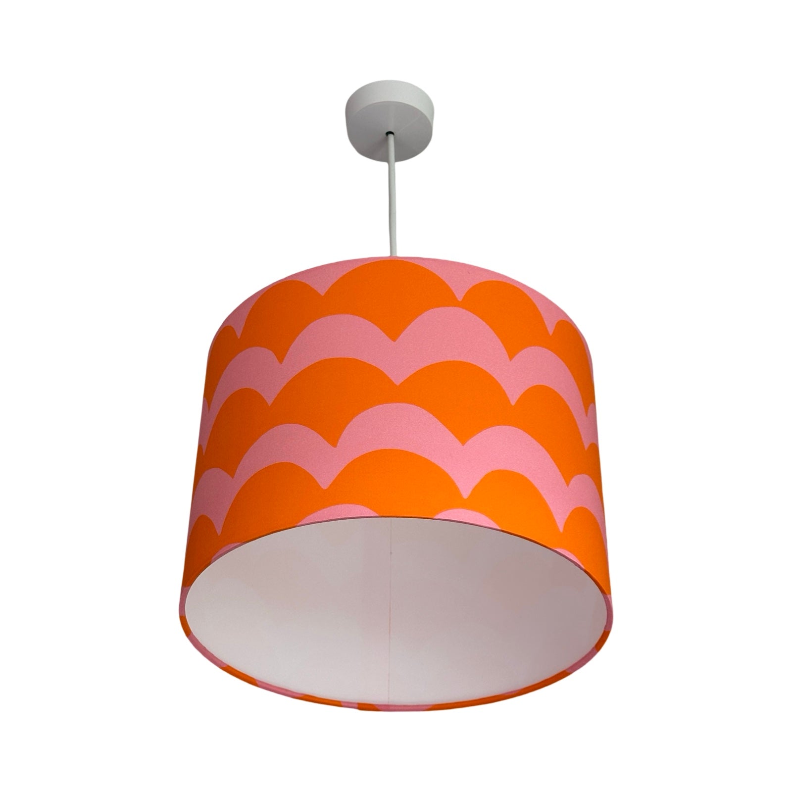 A drum lampshade in orange and pink cotton with a wave design