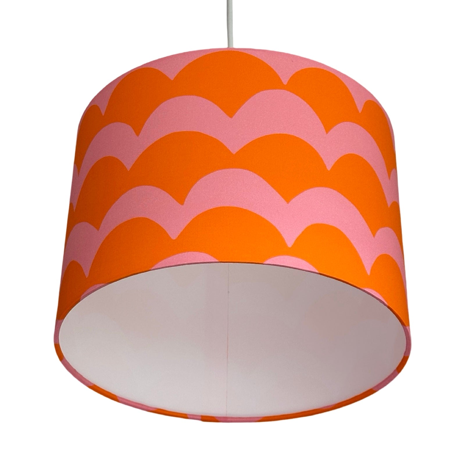A drum lampshade in orange and pink cotton with a wave design