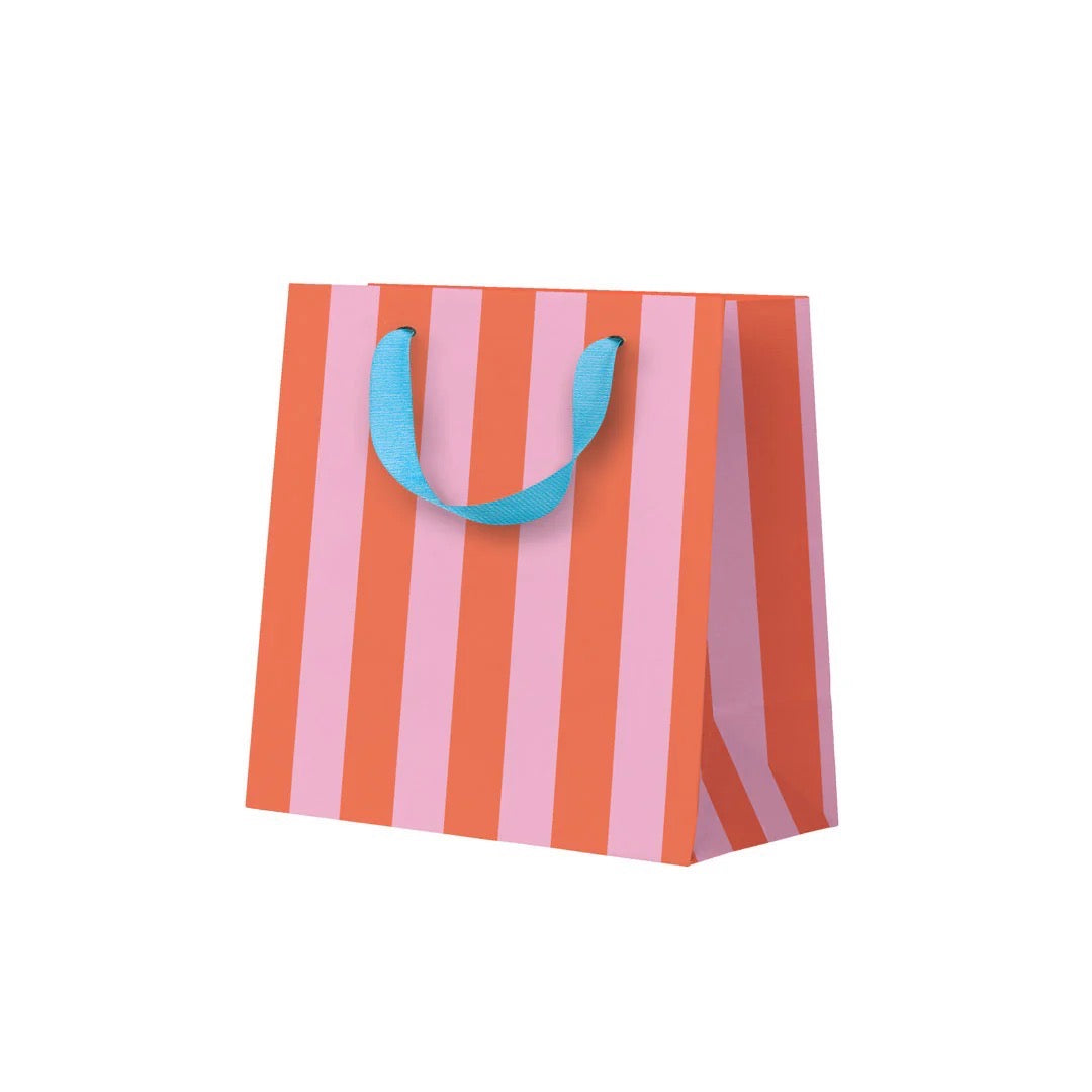 Striped paper bag with pink and orange stripes and blue handles on a white background.