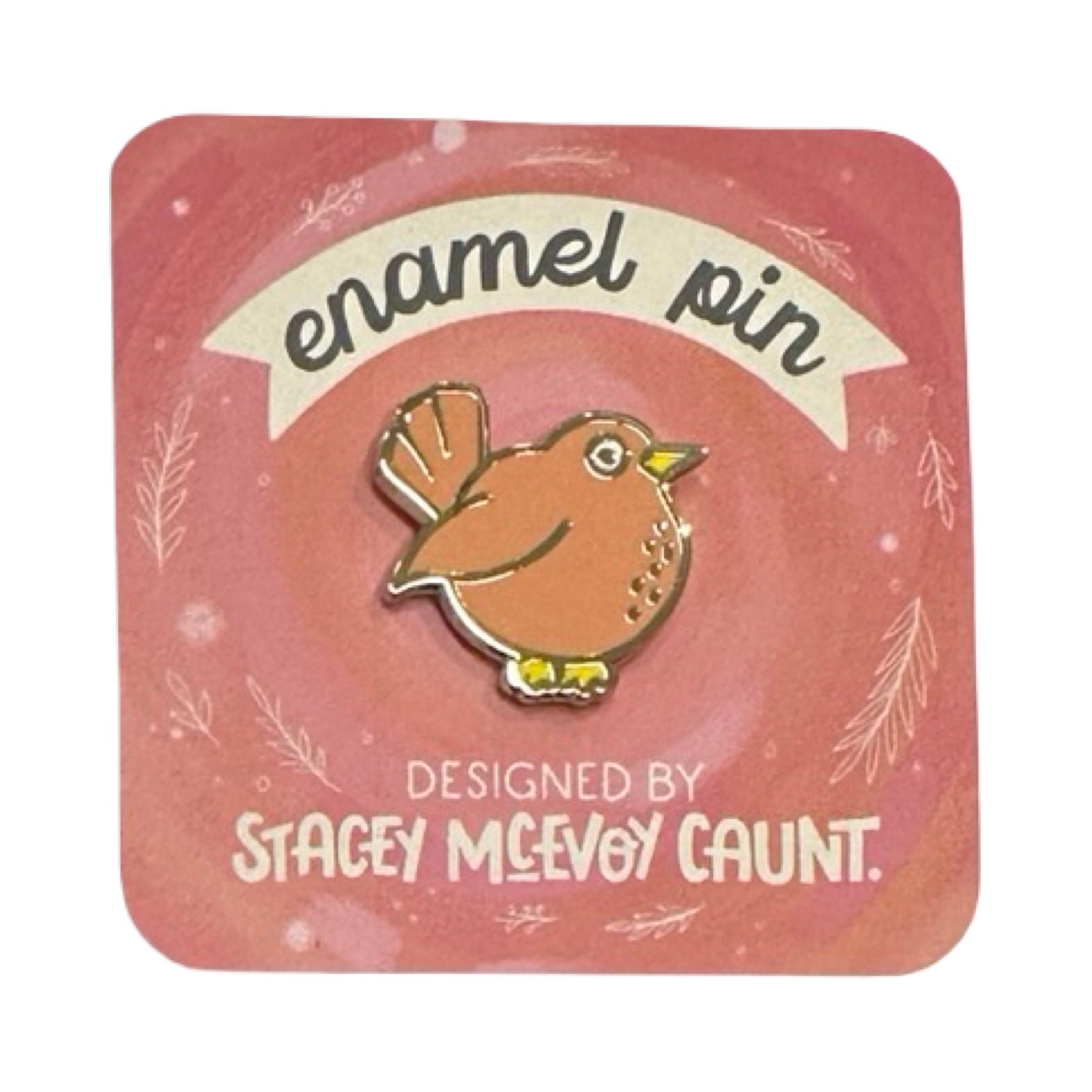 Enamel pin with a bird design on a pink card, designed by Stacey McEvoy Caunt.