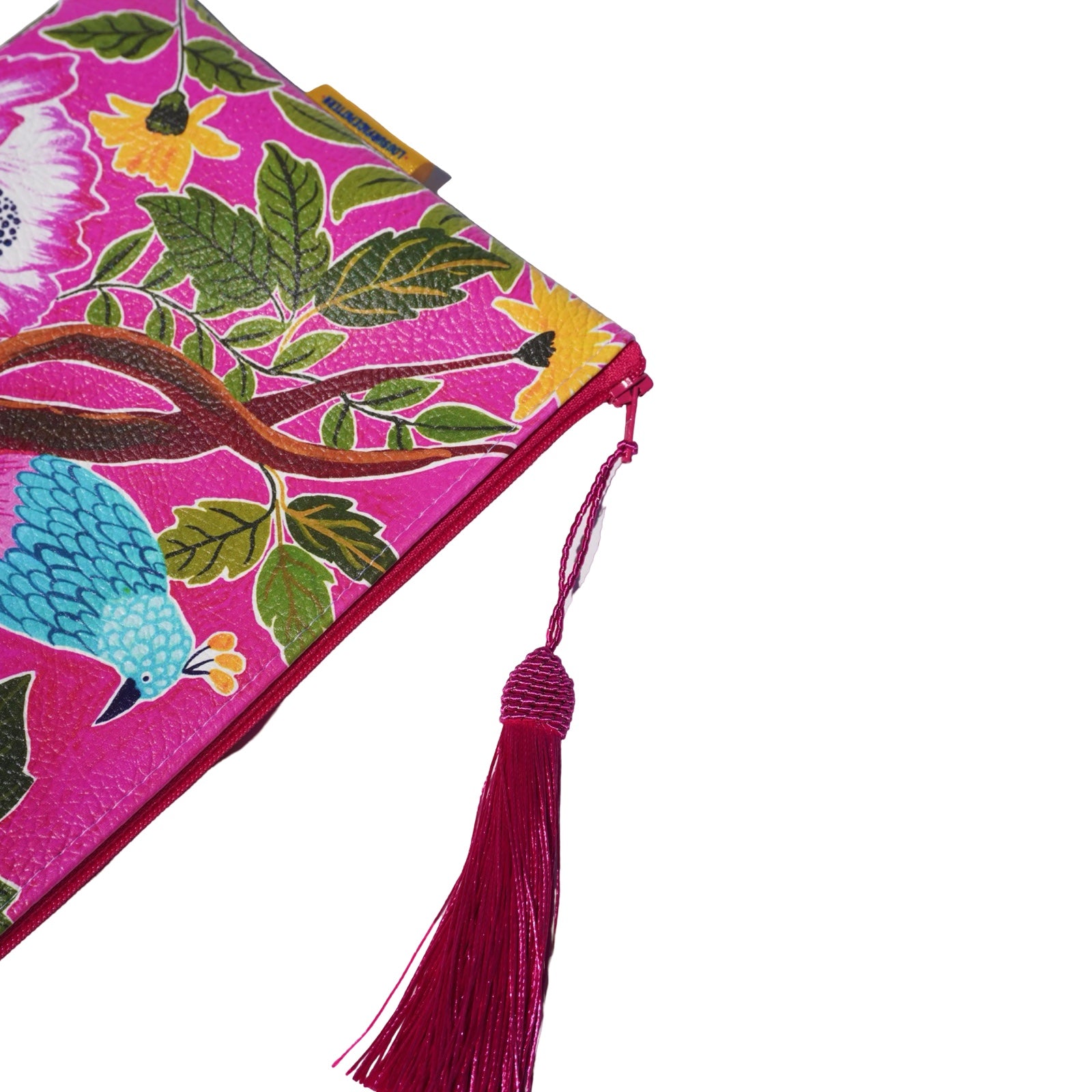 Vegan leather bag with a blue and pink bird perched on a branch surrounded by tropical leaves, and the bag is finished with a fabulous matching tassel on the end of the zip. 