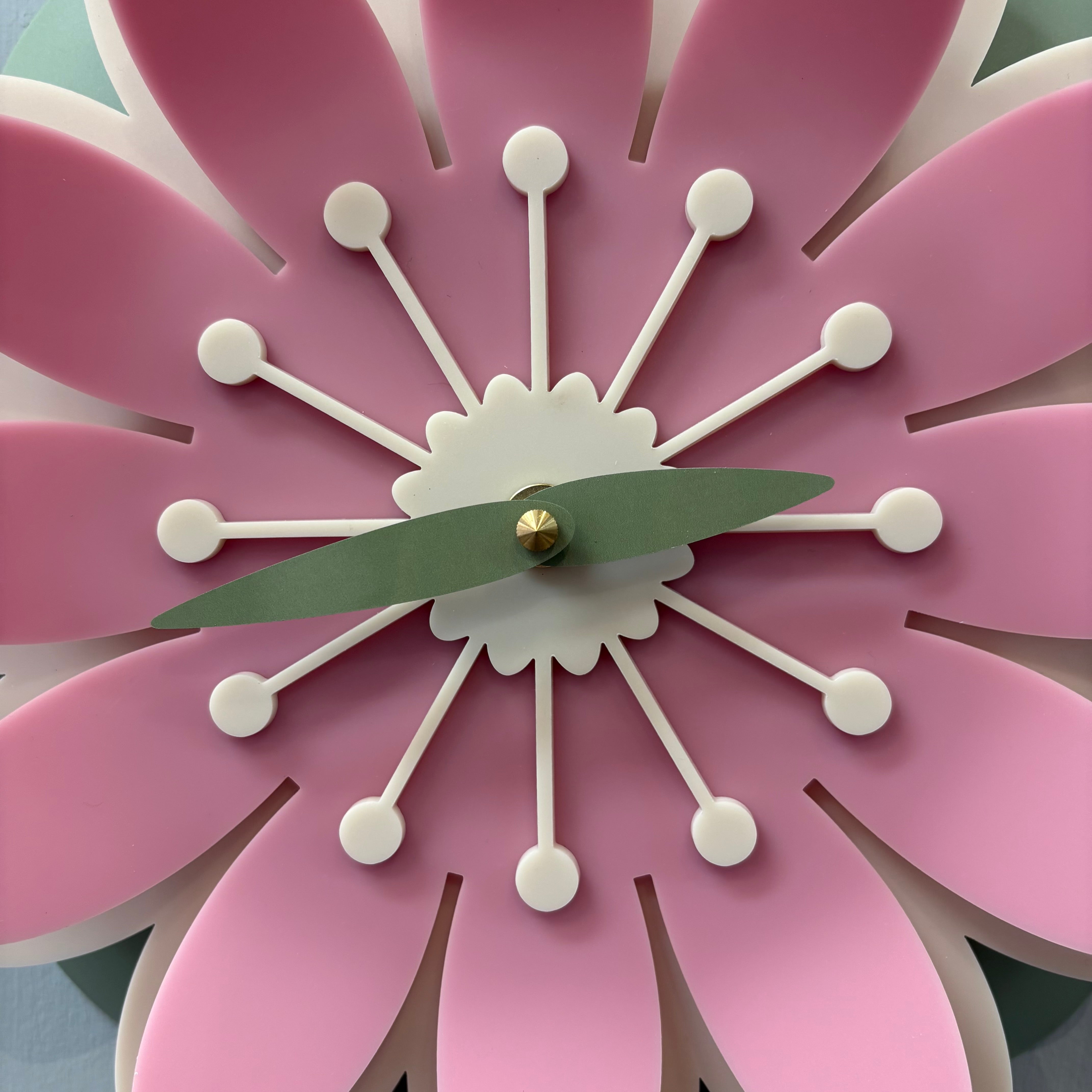 Pink flower-shaped clock with white stamens and green center.