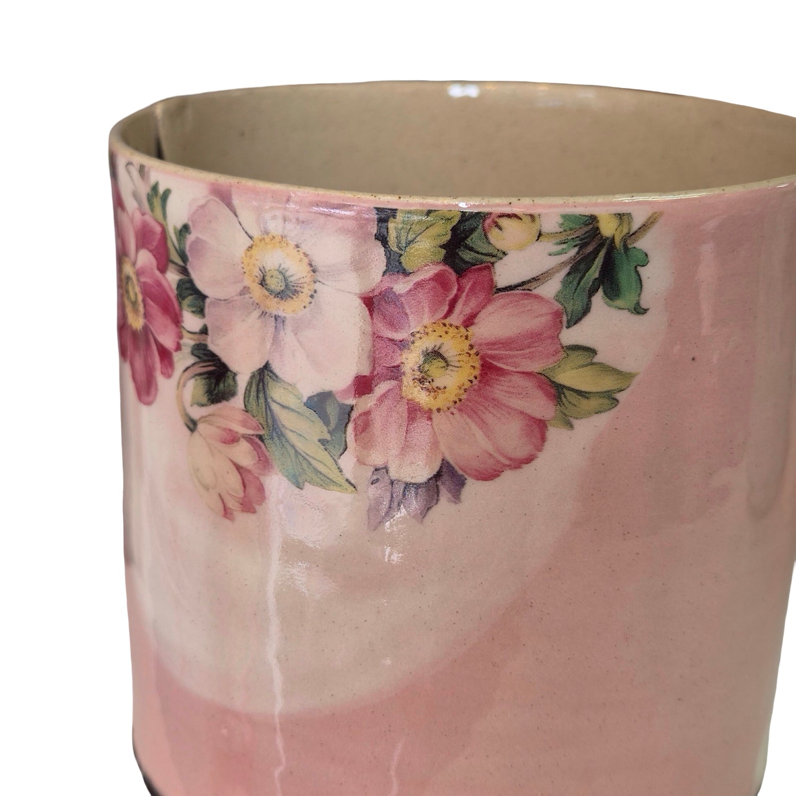 Pink ceramic planter with floral design on a white background.