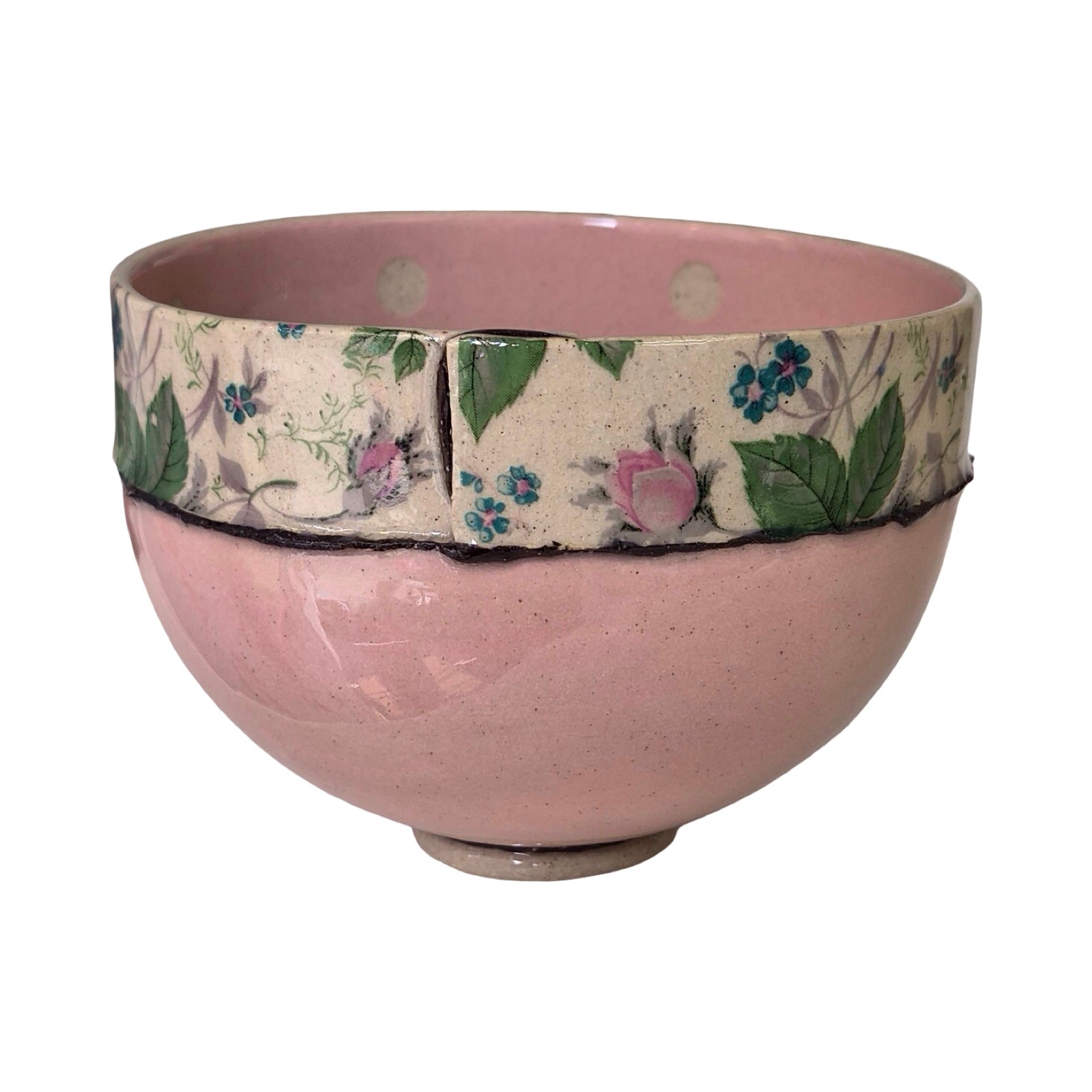 Pink ceramic bowl with floral patterned band on a white background.
