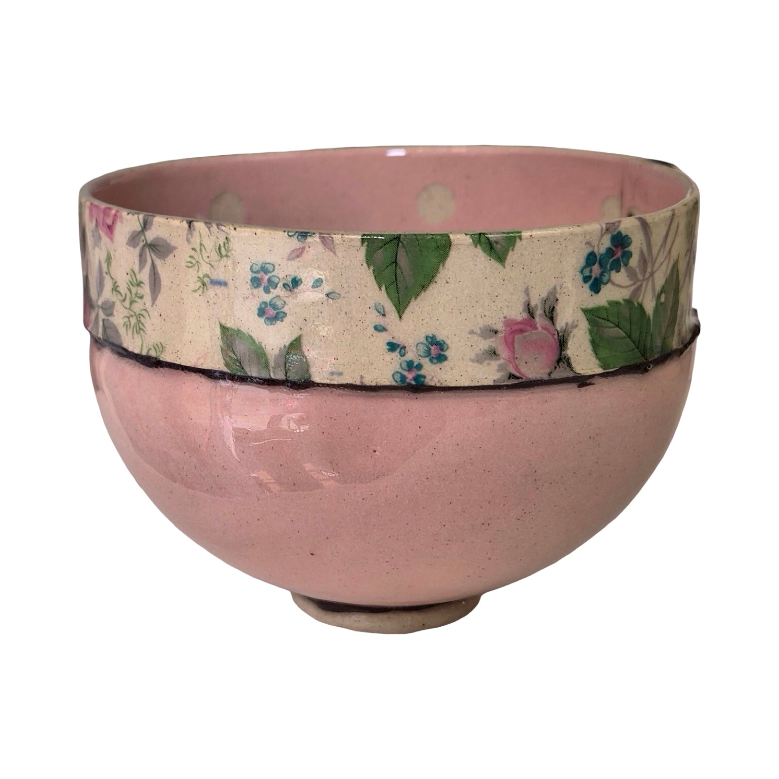 Pink ceramic bowl with floral patterned band on a white background.