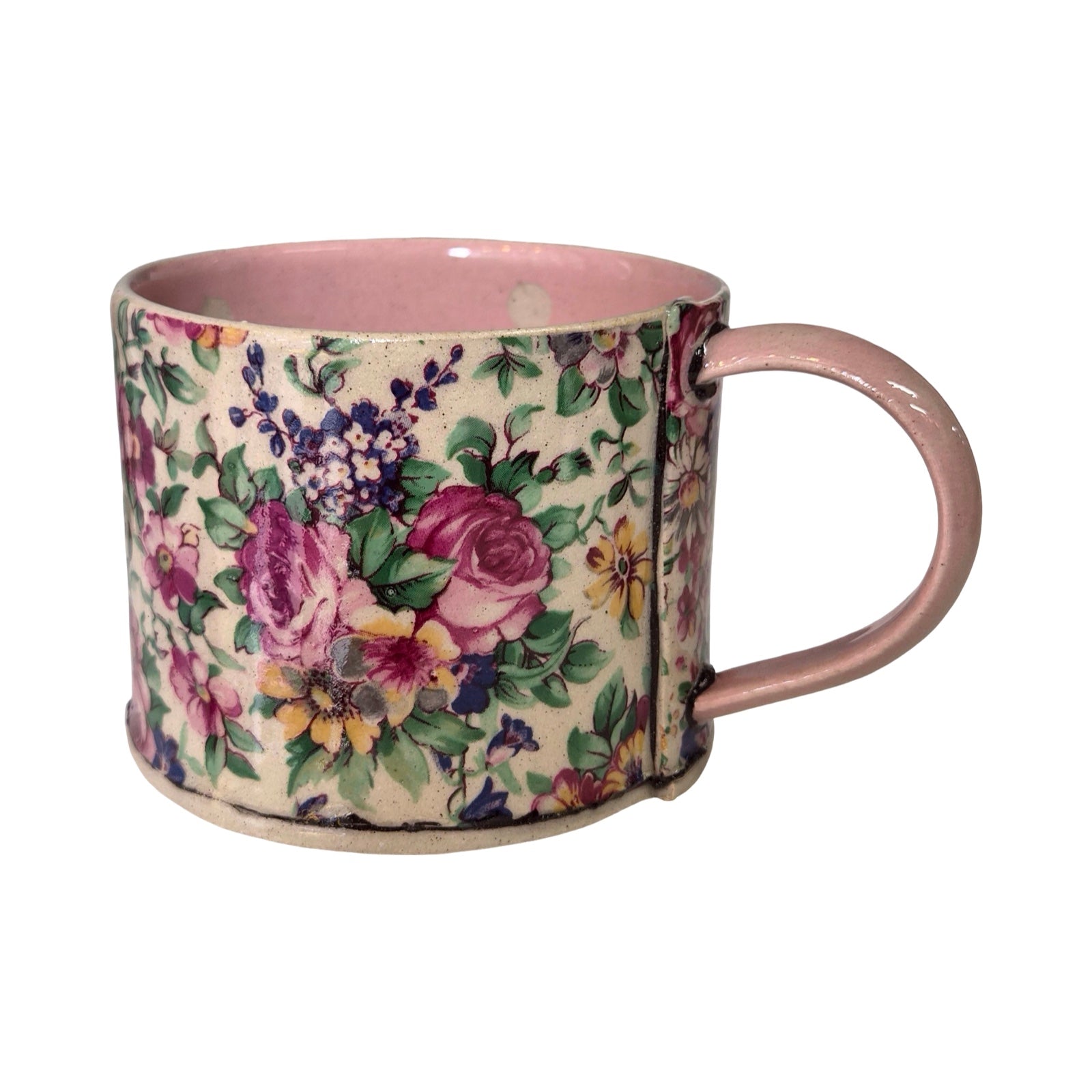 Floral-patterned mug with a pink handle on a white background.