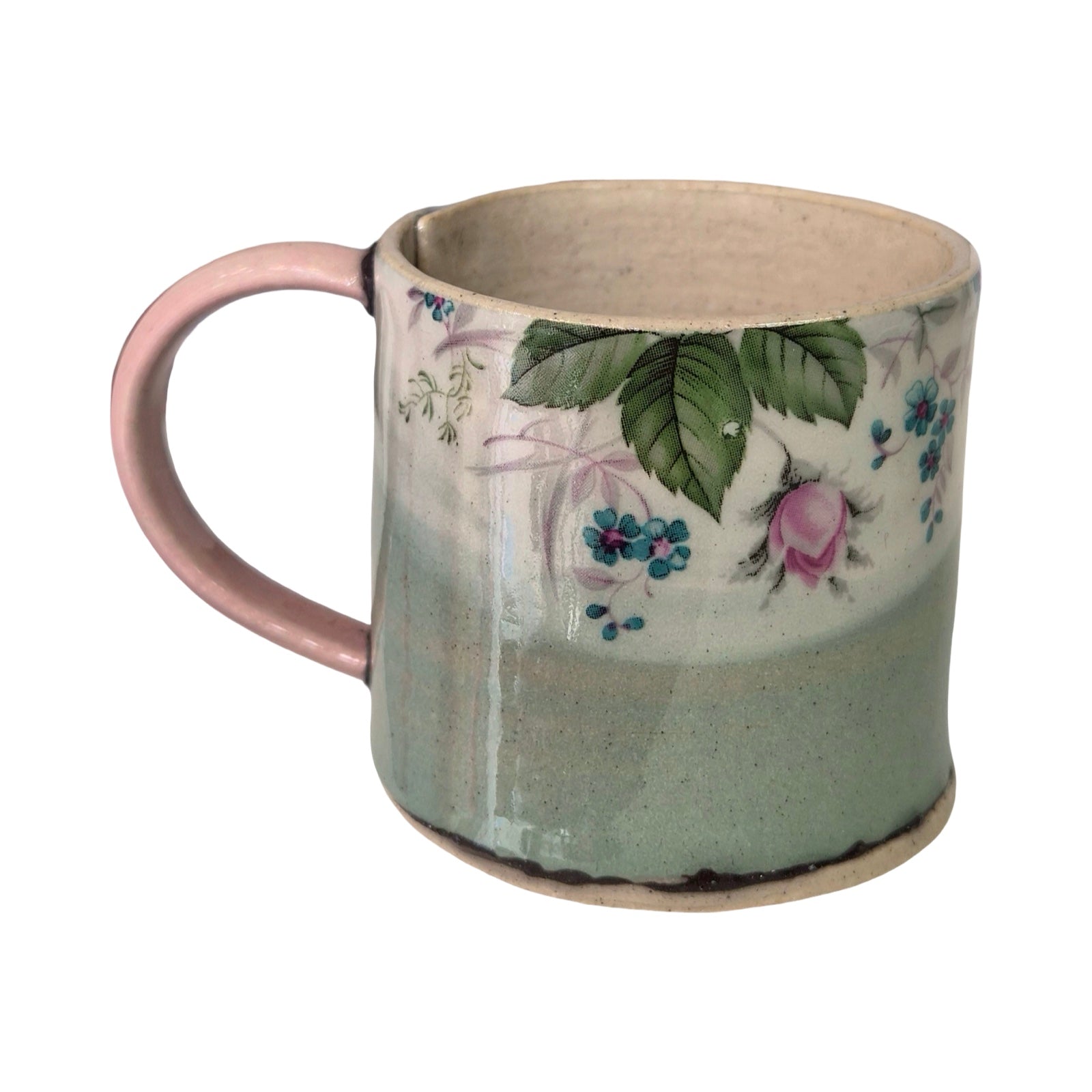 Ceramic mug with floral design and pink handle on a white background.