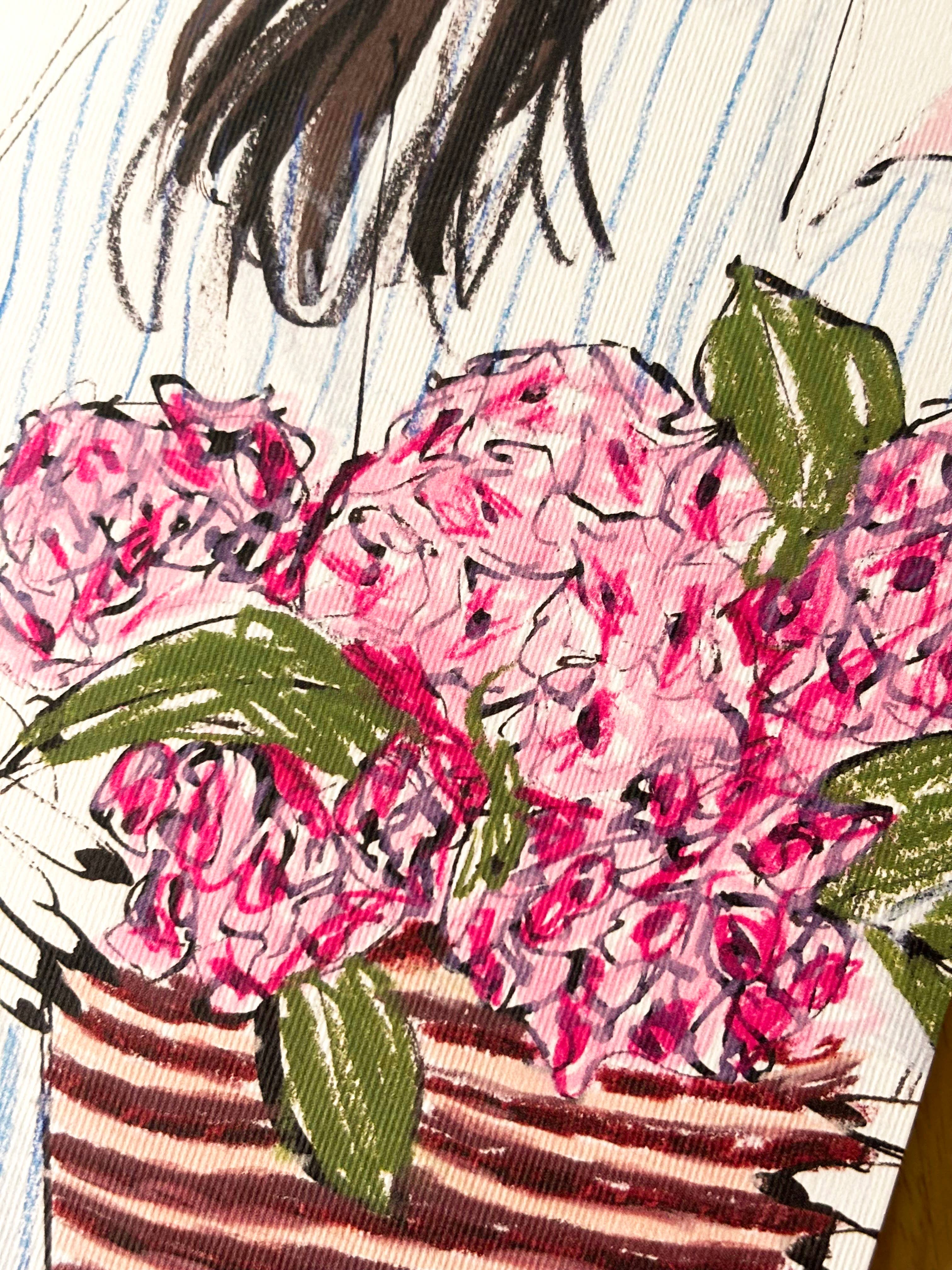 A close-up of a notebook featuring an artistic illustration of pink flowers with green leaves and dark hair on a striped background.