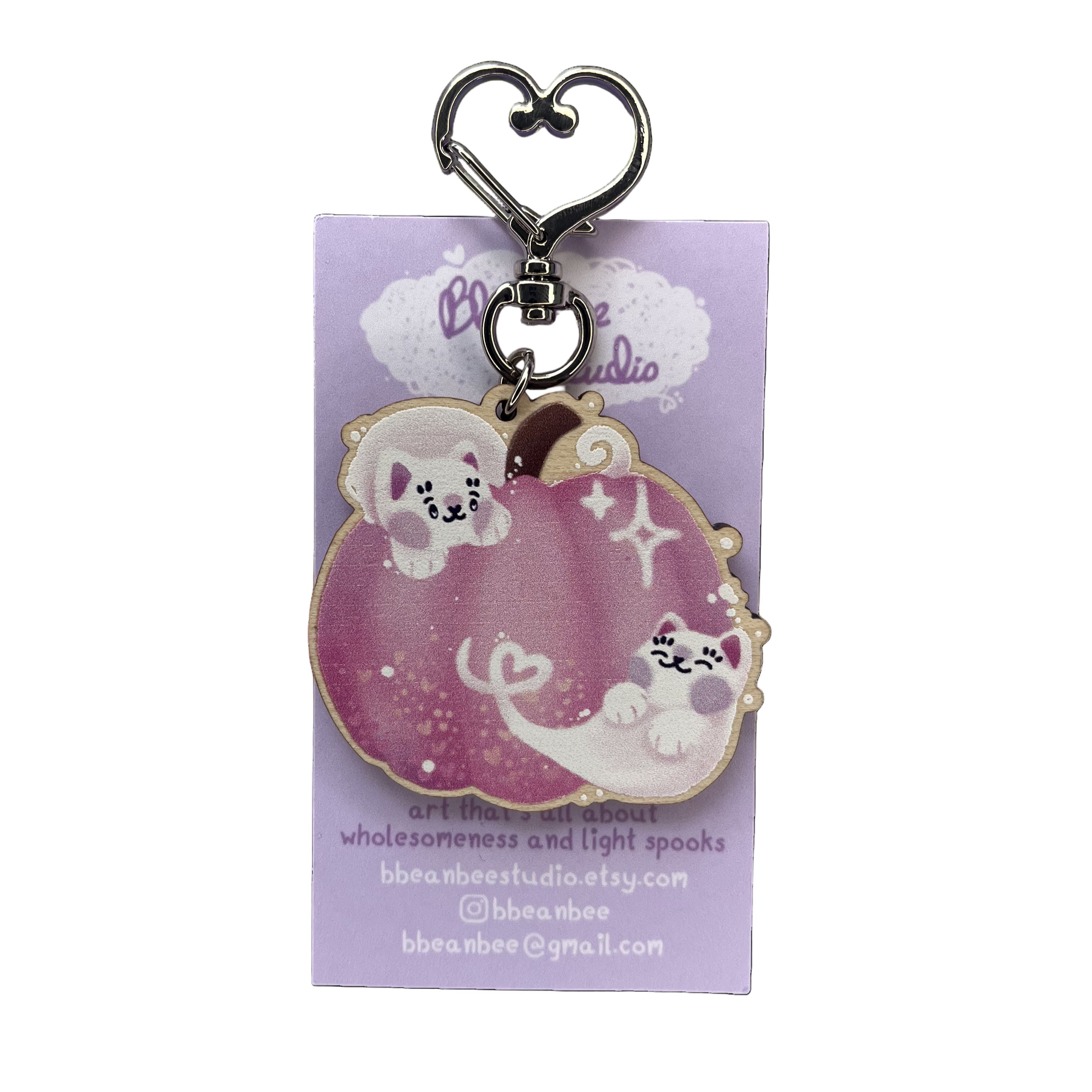 Pink pumpkin wooden keyring on a purple backing card.