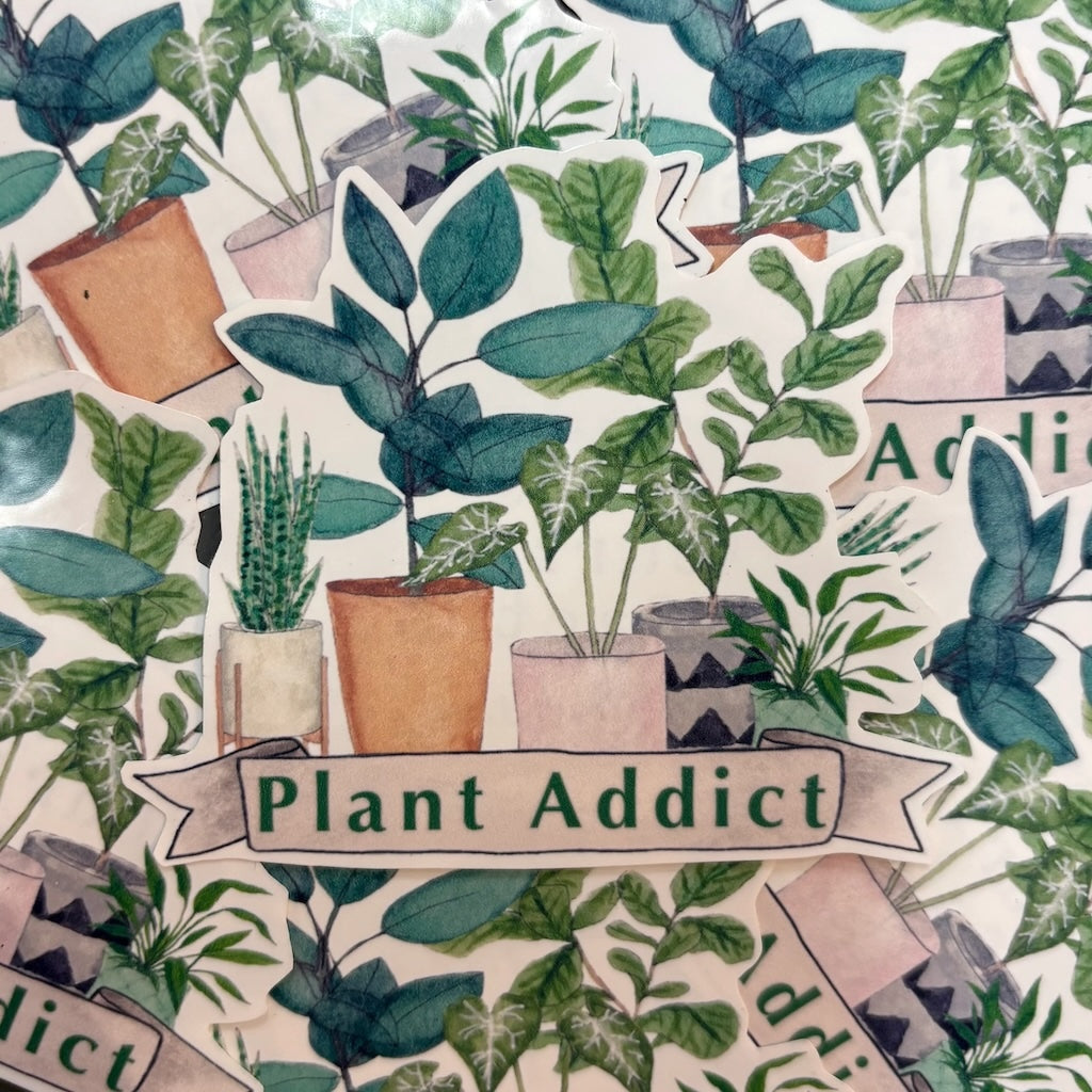 A vinyl sticker of a group of potted houseplants with the text 'Plant Addict' on a white banner.