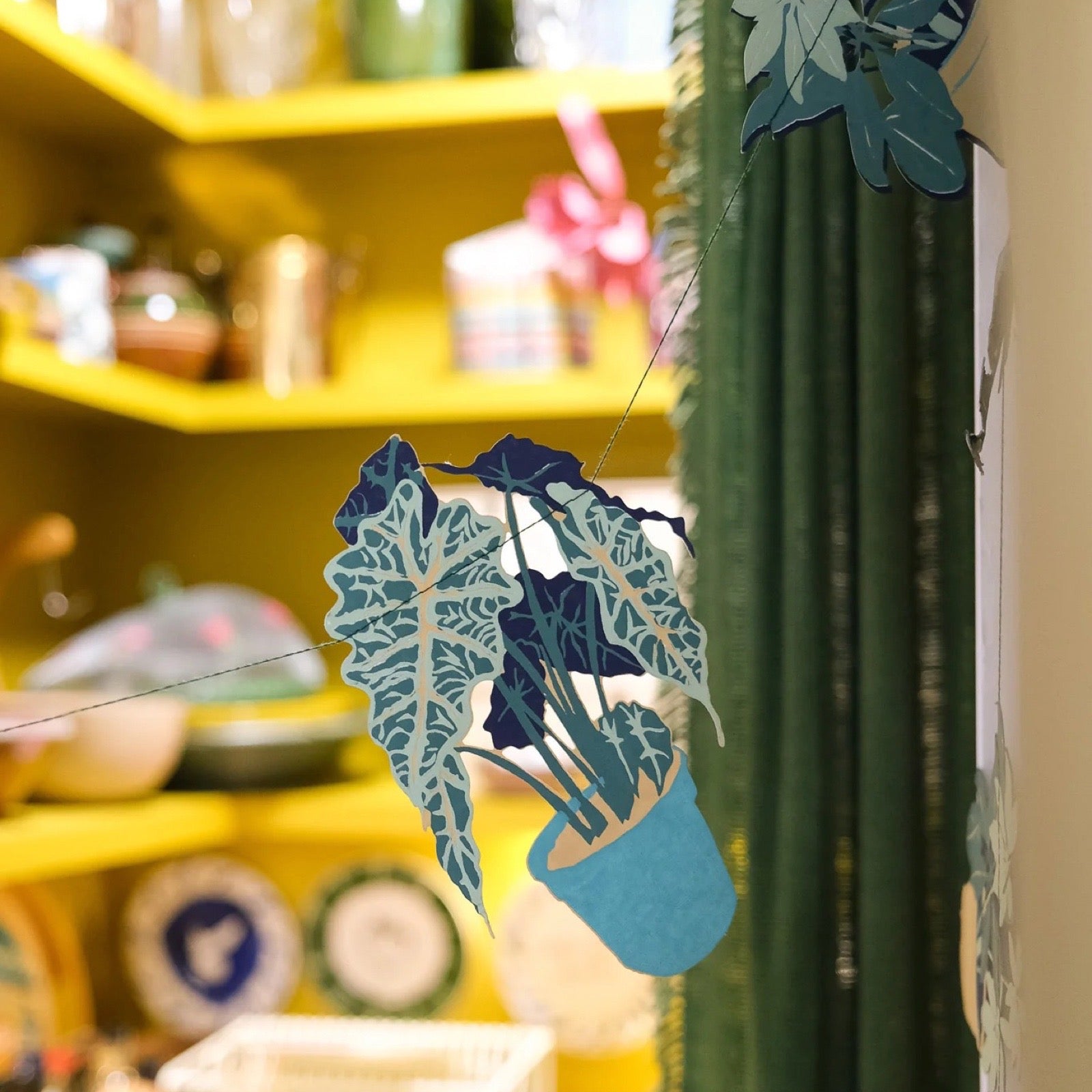 Close up of a houseplant garland strung up in a kitchen.