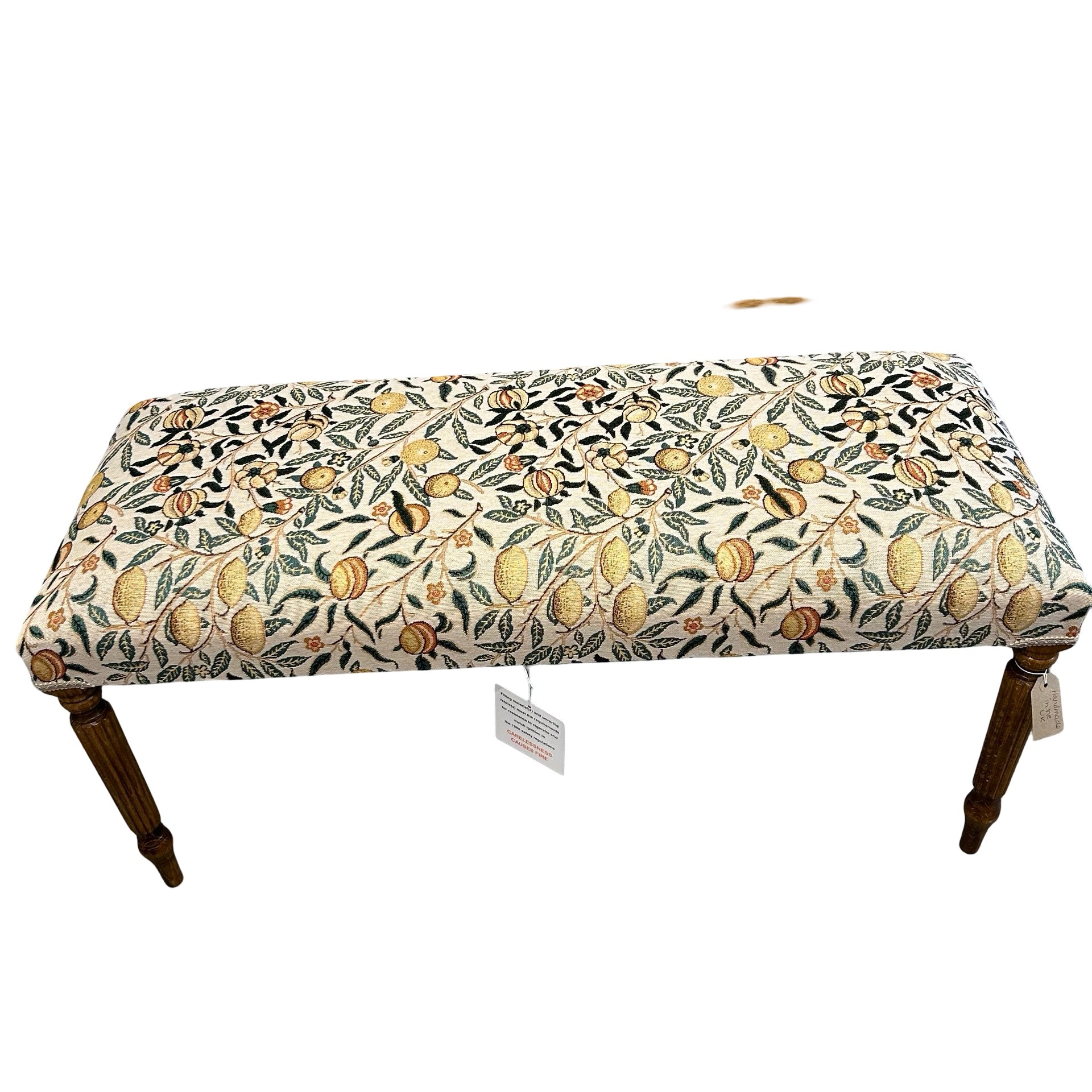 Decorative bench with floral and fruit pattern on a white background.